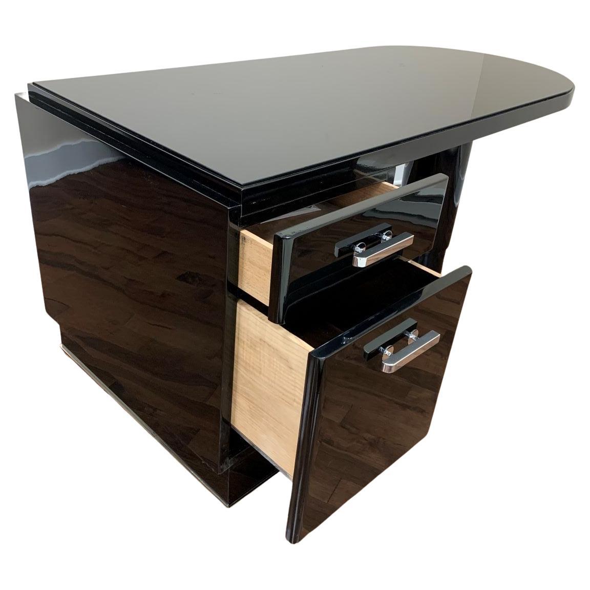 Remarkable French Art Deco Streamline executive desk. Simple chrome accents on the base complements the elegant design. The asymmetric design features a drawer bank with a file drawer opposite a stately cylinder leg. The top is black glass for