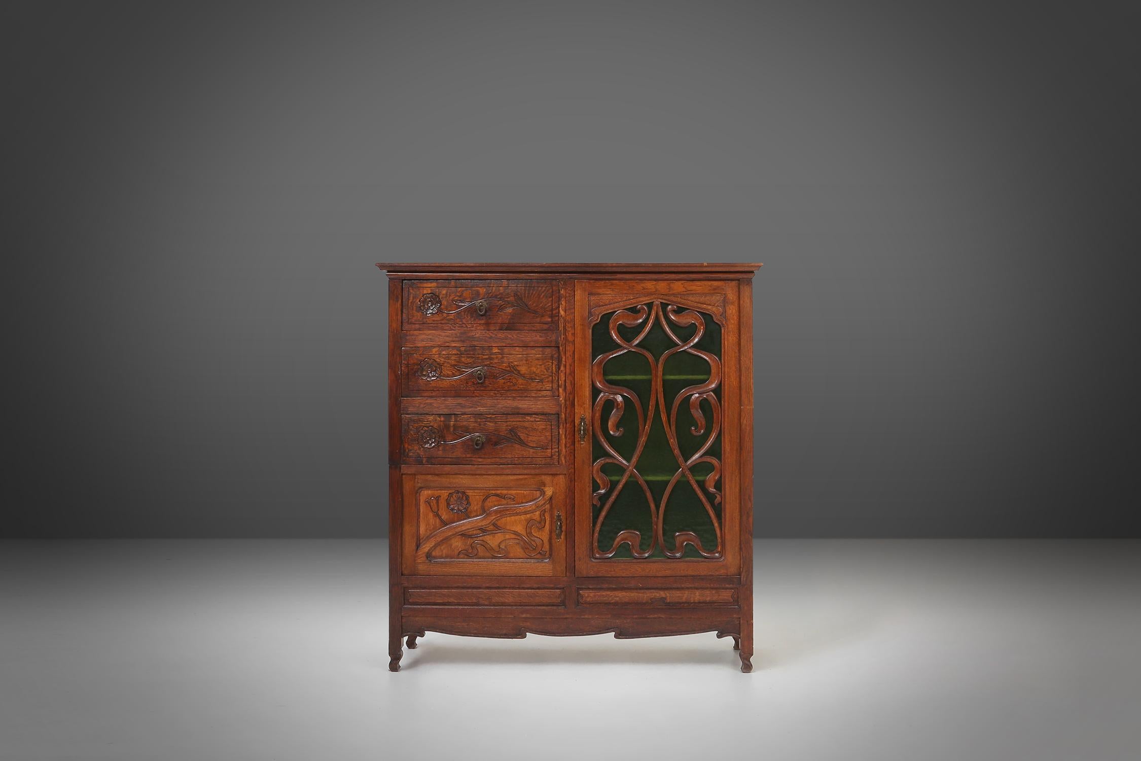 France / 1910 / cabinet / oak and green glass / Art Nouveau

Remarkable French cabinet with typical art nouveau floral decoration and green glass door. The cabinet distinguishes itself with striking design and rich luxurious carved decoration in