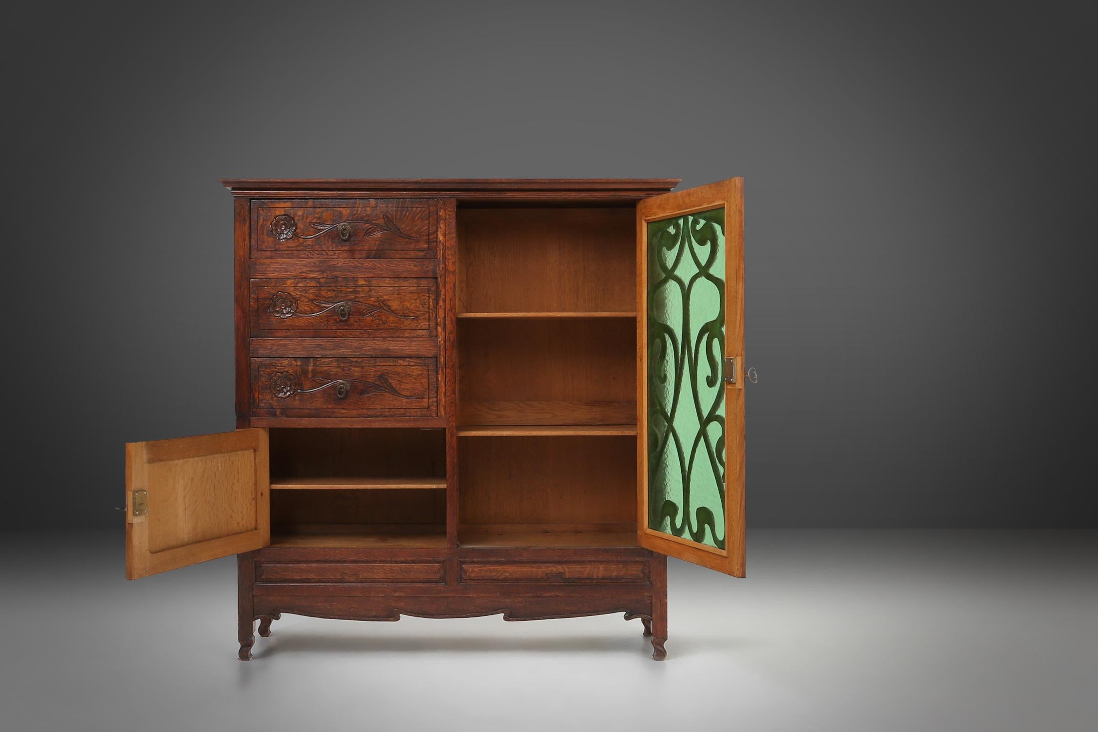 Hand-Carved Remarkable Art Nouveau cabinet in oak with green glass door, France, 1910 For Sale