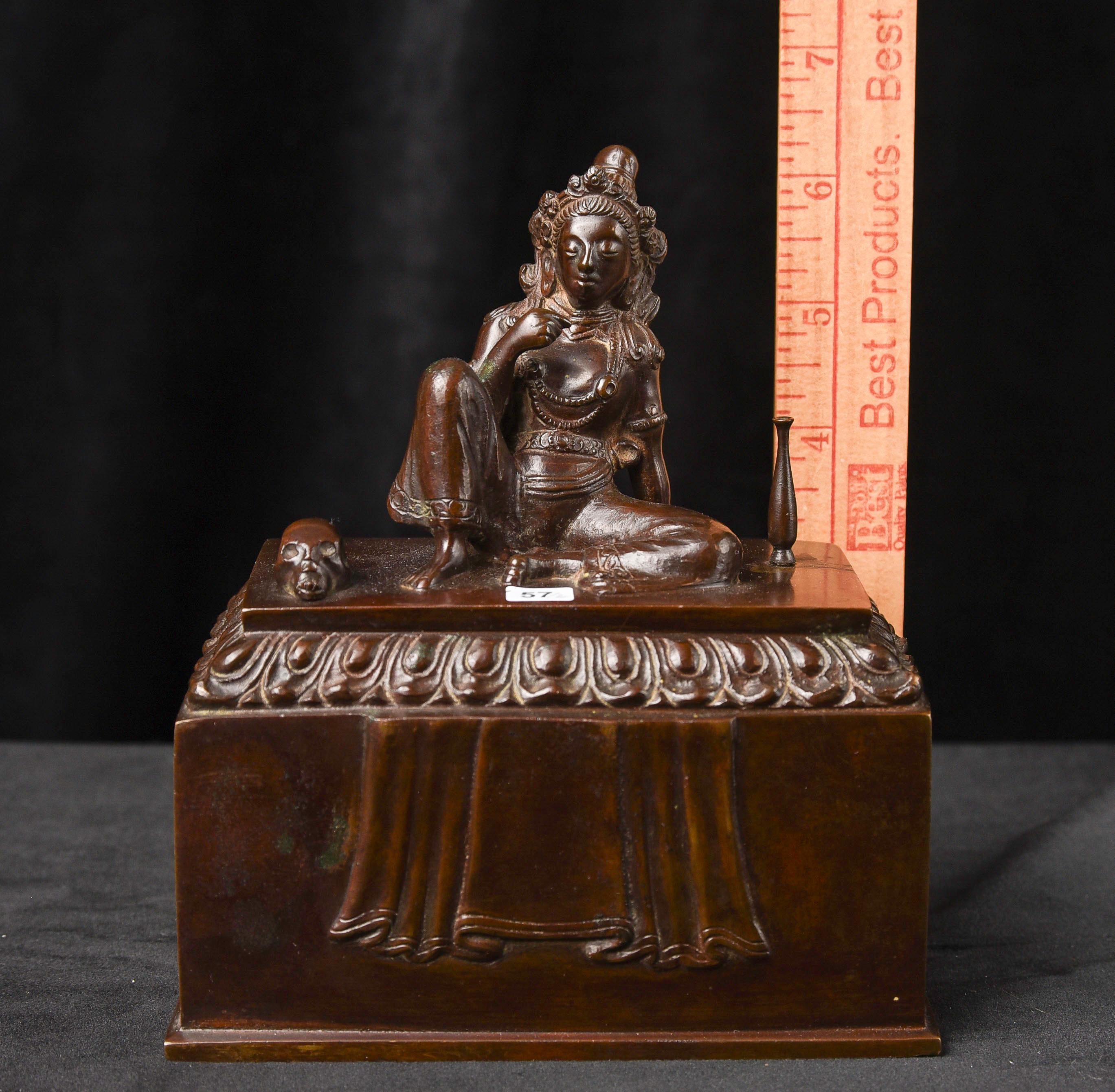 Remarquable boîte antique en bronze bouddhiste tantrique du Tibet ou du Laos - Le couvercle présente une figure féminine assise dans une pose détendue, avec un crâne et un vase à ses côtés. Sur une base rectangulaire, l'intérieur représente un