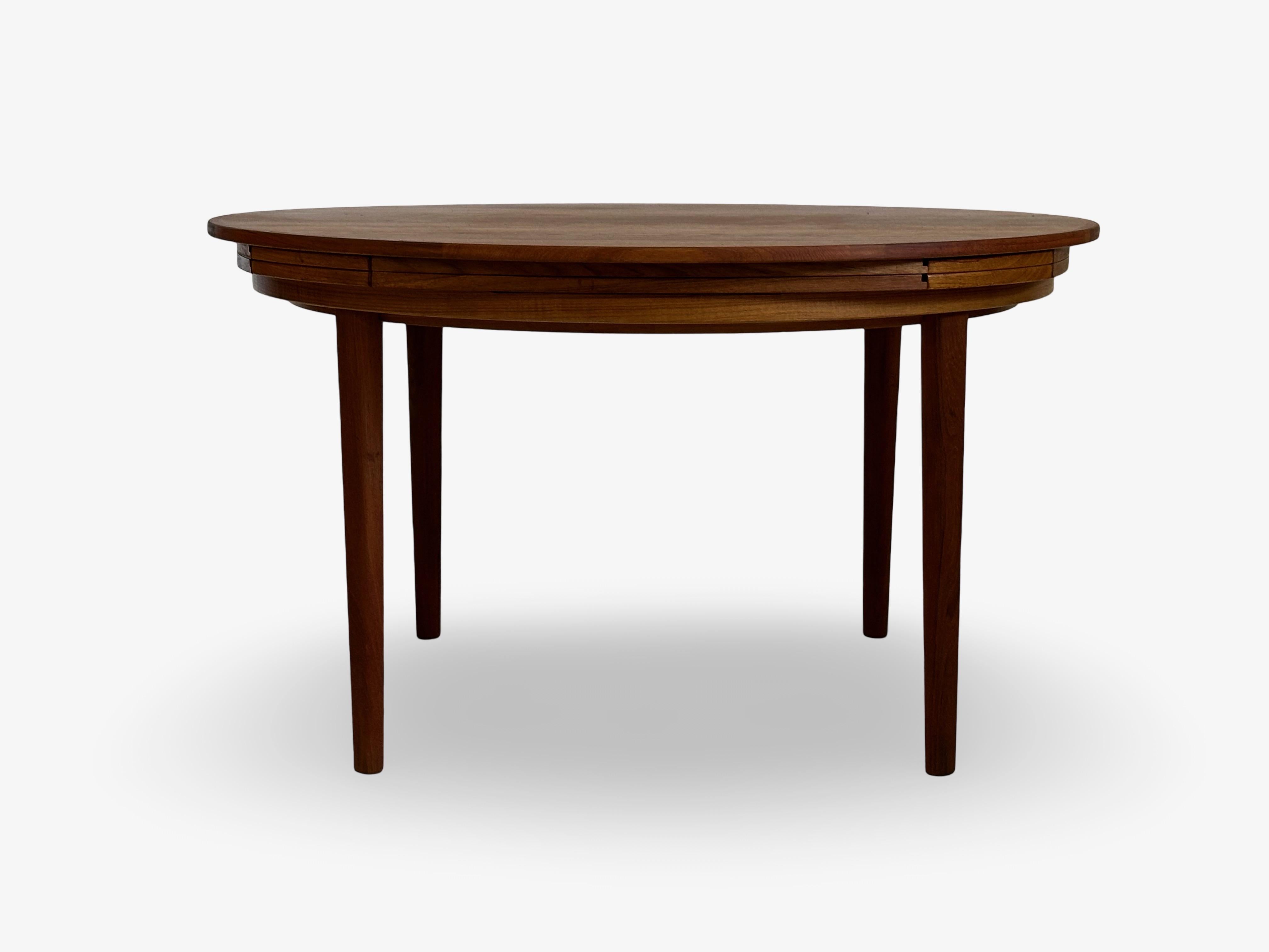 Dining table that extends. Round model designed and produced by Dyrlund Møbler, Denmark.
The extension is placed underneath and pulls out and flips open to extend the table top. Max Ø is 180 cm.