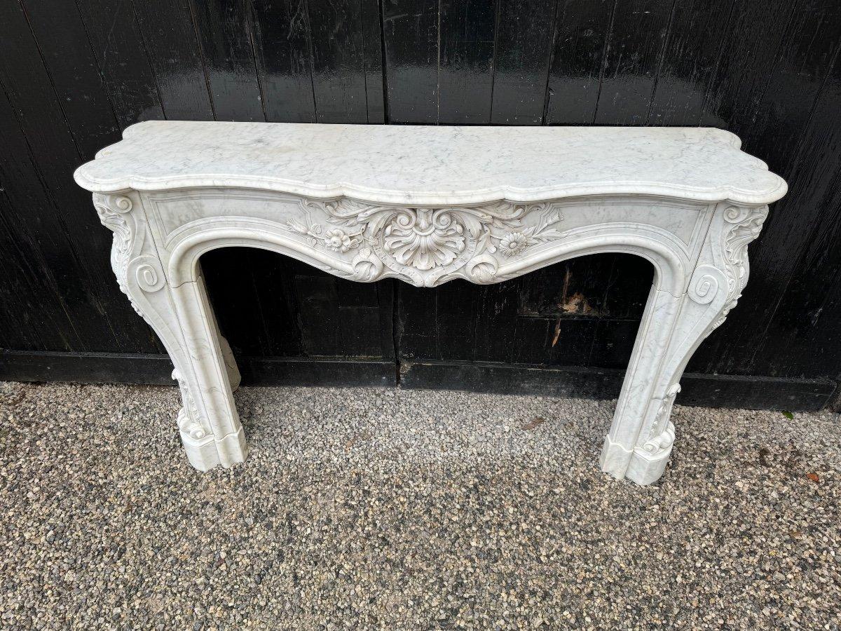 Cheminée de style Louis XV En marbre blanc de Carrare, sculpture de très haute qualité, panneaux à double moulure sur les côtés. 

Dimensions de la cheminée : 78,5 x 107,5 cm