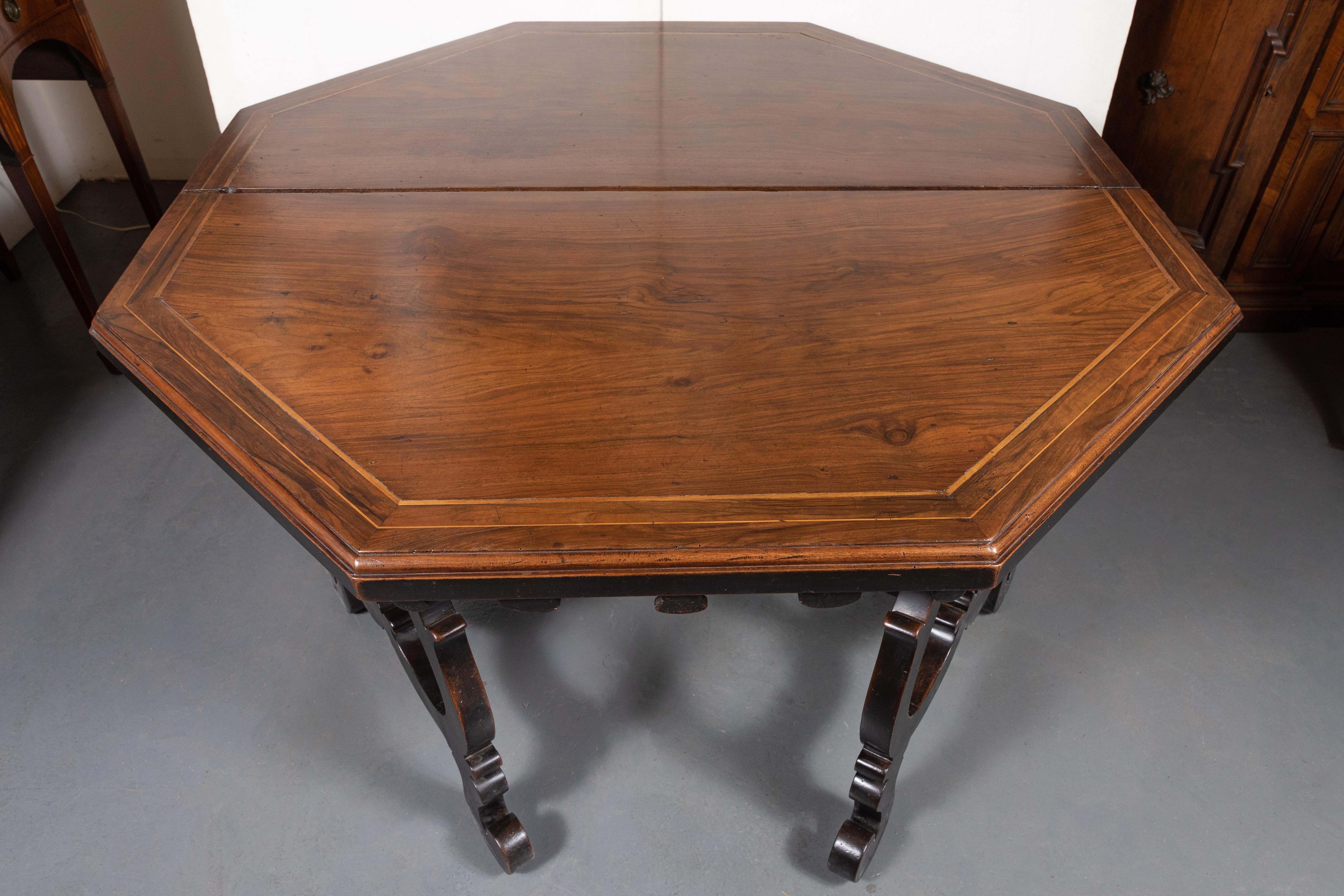 Pair of extremely rare, large, circa 1835, hand carved and inlaid, walnut demilune from Lombardi, Northern Italy. The beveled edge tops sit above remarkable, ebonized, scrolling bases featuring rounded wood stretchers that are almost never seen.