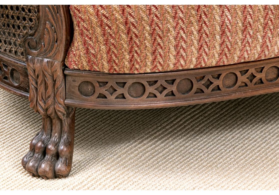 Paire de fauteuils club de style français de très bonne facture et superbement décoratifs, avec des côtés et des dossiers en rotin à double paroi et des cadres aux tons profonds avec des accoudoirs légèrement inclinés, une délicate décoration