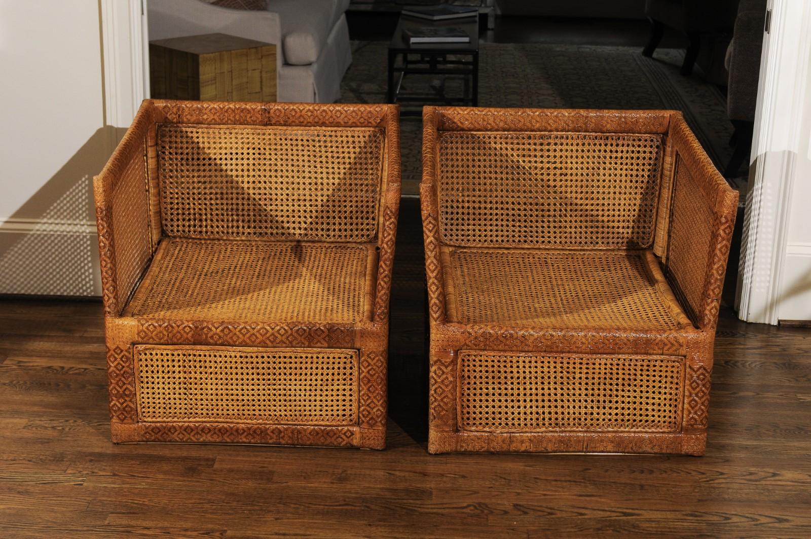 A jaw-dropping unique pair of custom-made cane cube club or lounge chairs, circa 1970. Solid mahogany frame painstakingly hand-wrapped in cane executed to look like rattlesnake, with French cane inset panels. Design, craftsmanship and quality that