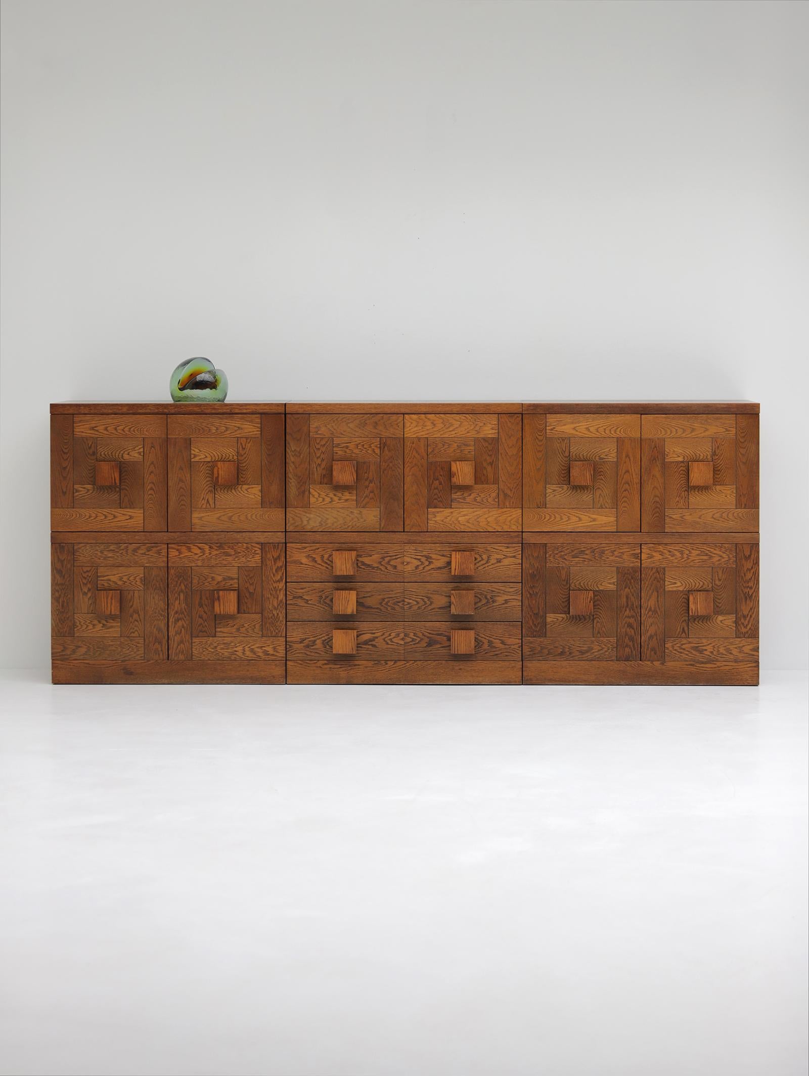 A remarkable set of cabinets, designed and produced by Defour Belgium in the 1970s. The front facade features a geometric pattern featuring large wooden door knobs. This combination gives the cabinets a dynamic look. Placed next to each other, a