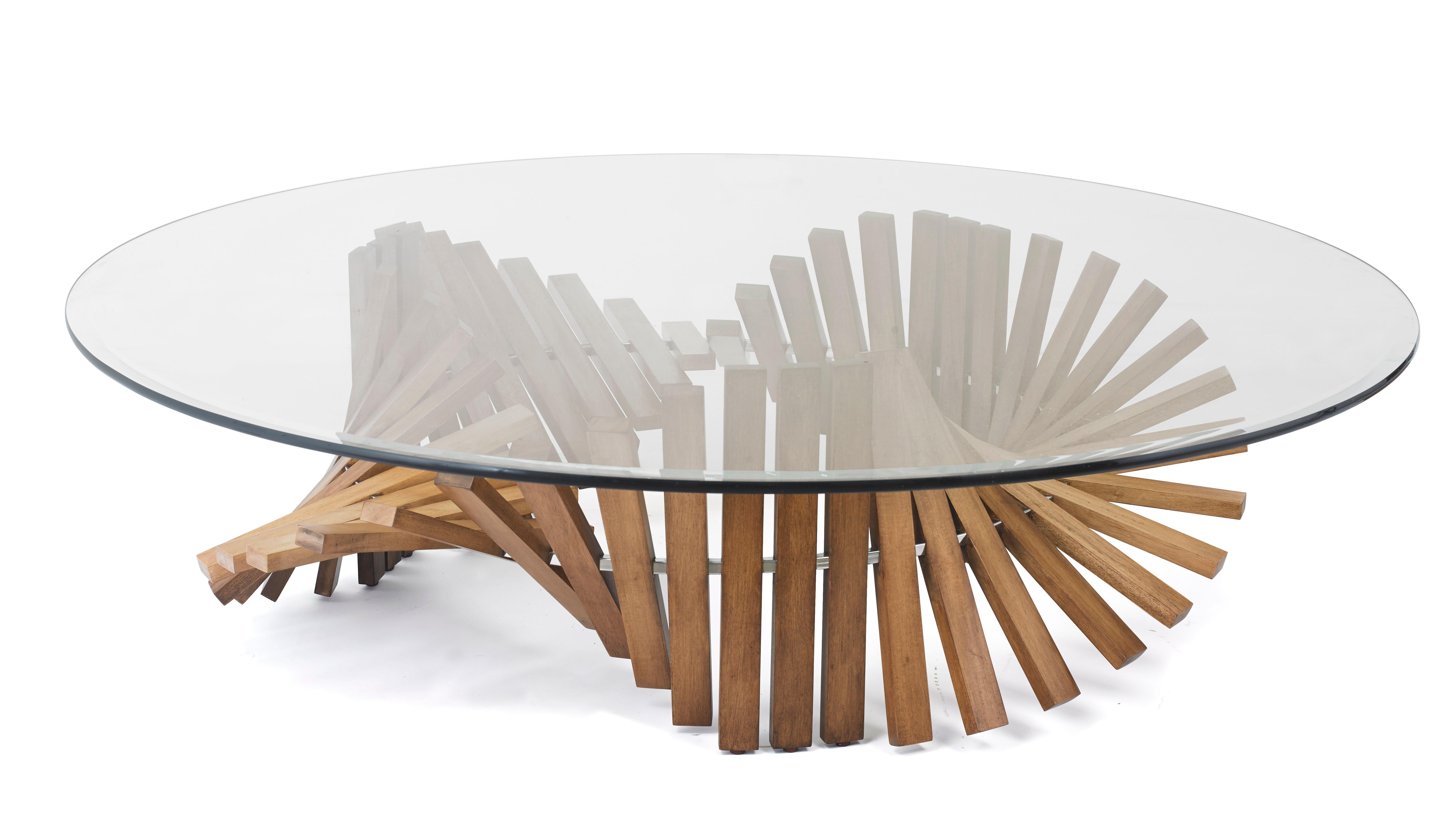 The cocktail table base is a marvel of natural wood, featuring captivating undulations that create an extraordinary design. Designed by the visionary Vito Selma, known for his ability to conceive the unimaginable, this piece is a testament to his