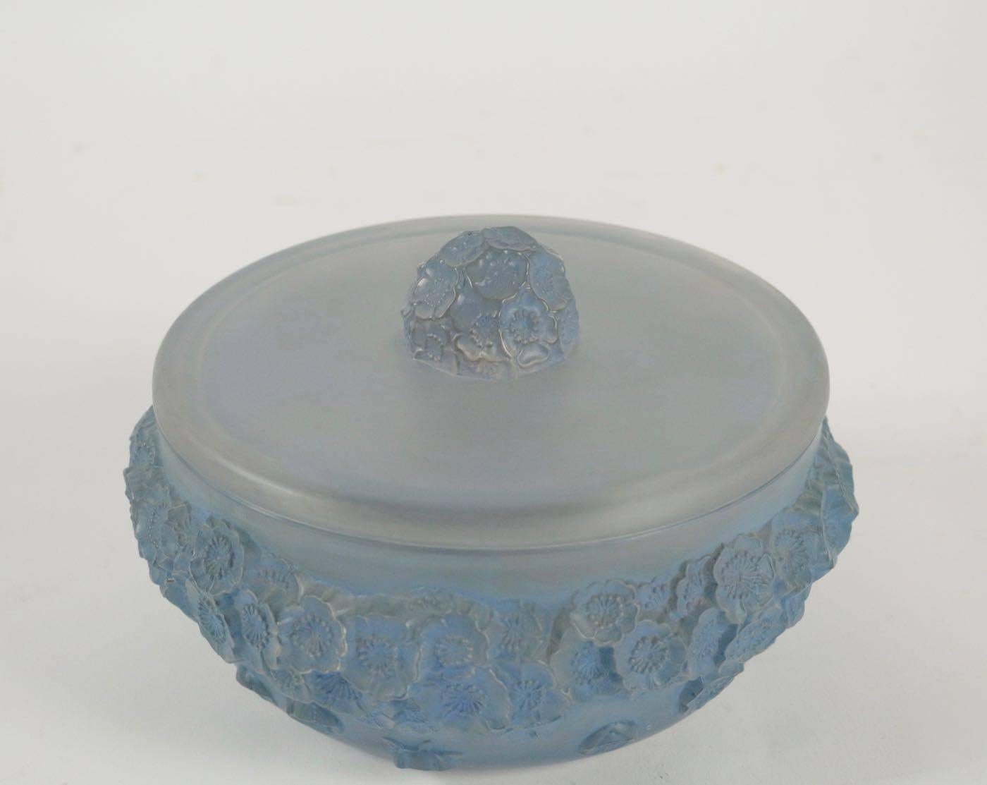 René Lalique (1860-1945), box Primevères
Frosted heavy glass the bowl form bottom with a relief floral decoration circling around the entire side, and the undecorated flat lid with a matching motif central dome shaped handle R. Lalique Box. Model: