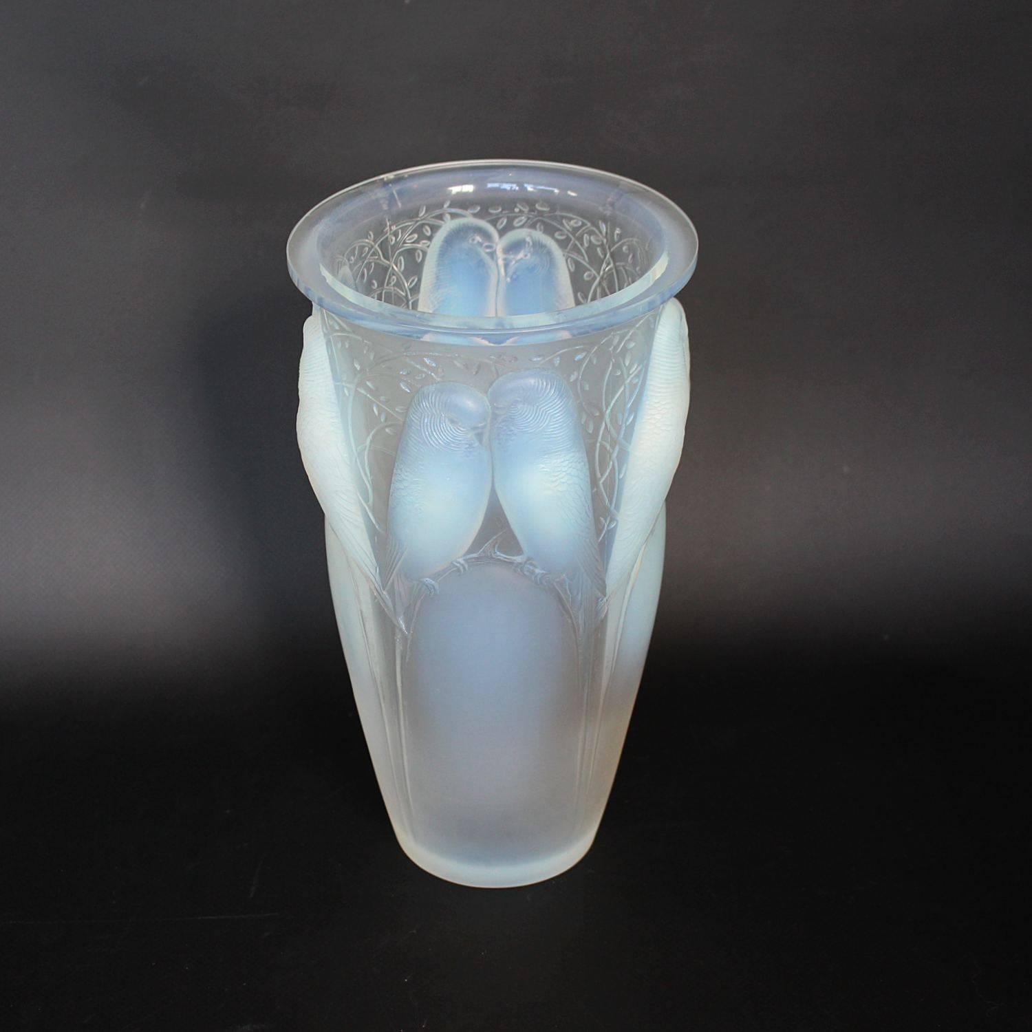 Ceylan, an Art Deco glass vase. A frosted and opalescent glass vase, relief decorated with pairs of lovebirds and vines.

Etched R Lalique France to underside.

Marcilhac, R Lalique Catalogue Raisonné de L’Œuvre de Verre p.418, Model number