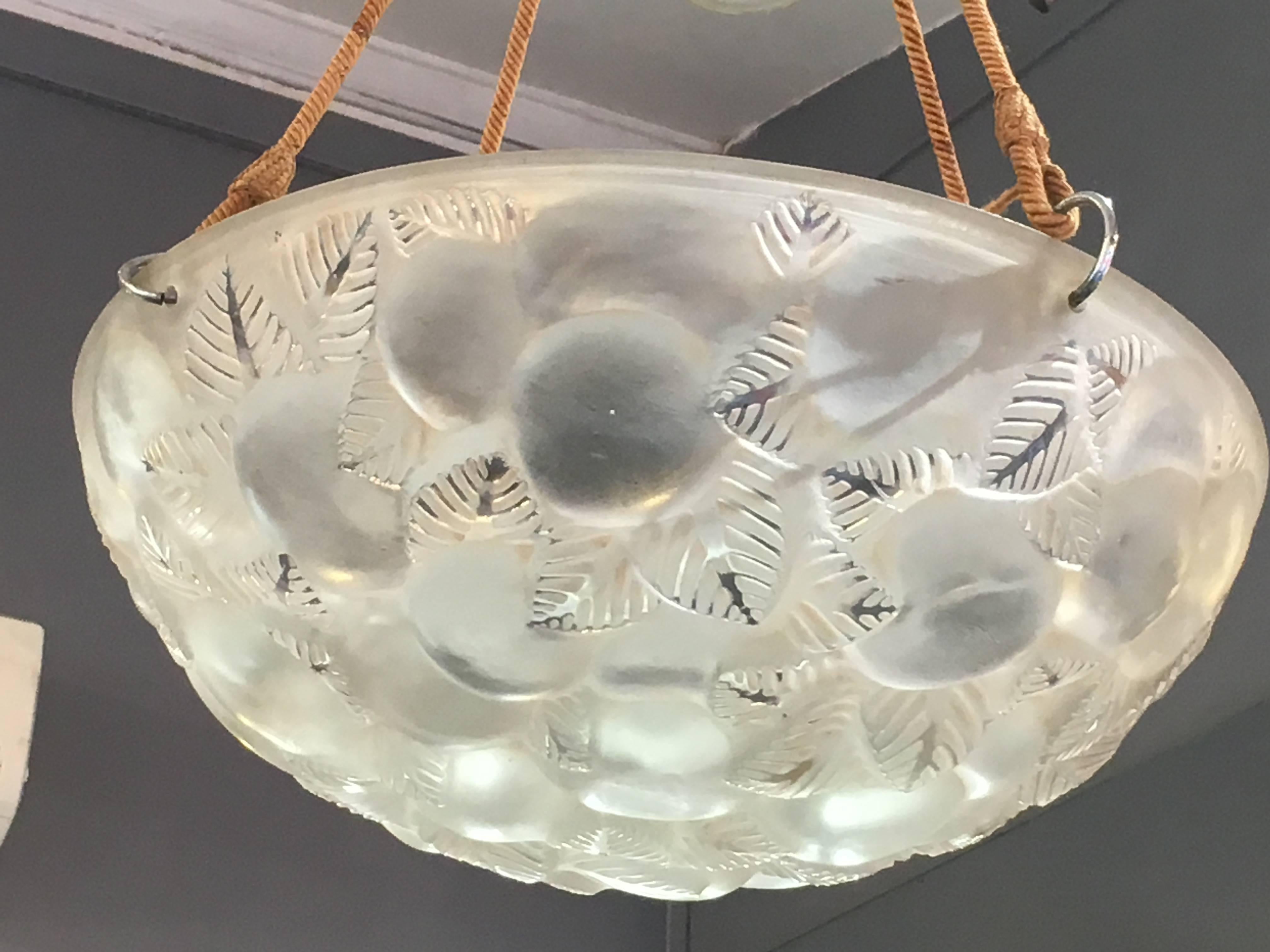 “Lausanne” chandelier, a design created in 1929, in molded glass, diameter: 15” (38 cm.) hanging from four electrified silken cords and glass canopy. Total drop is adjustable
