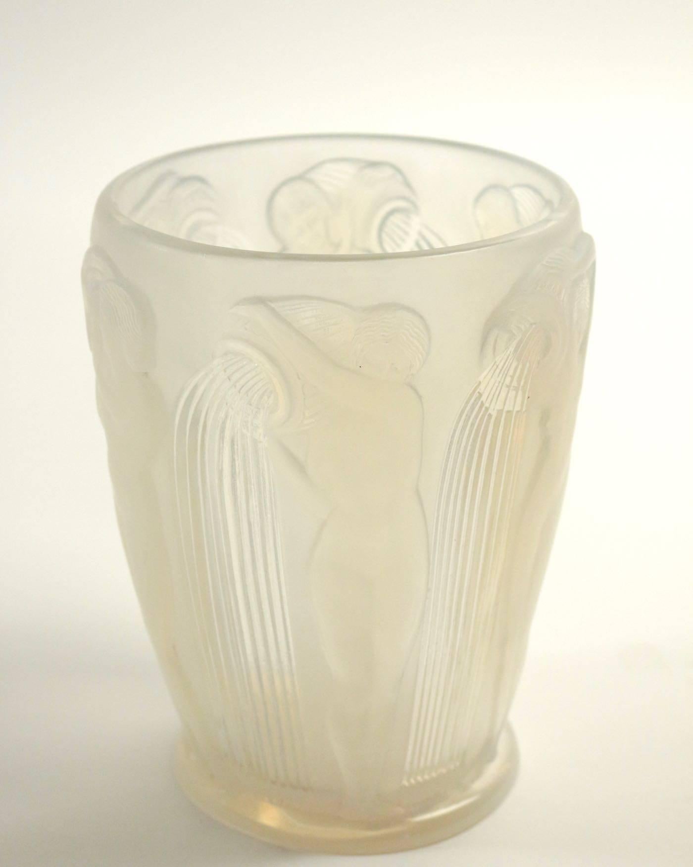 High opalescent press-molded glass with a design of nude women pouring water from large shoulder jugs.
'Danaides' a vase, design 1926
opalescent glass, frosted and polished.
Measure: 18.5cm high, engraved 'R. Lalique France'
Marcilhac no. model: