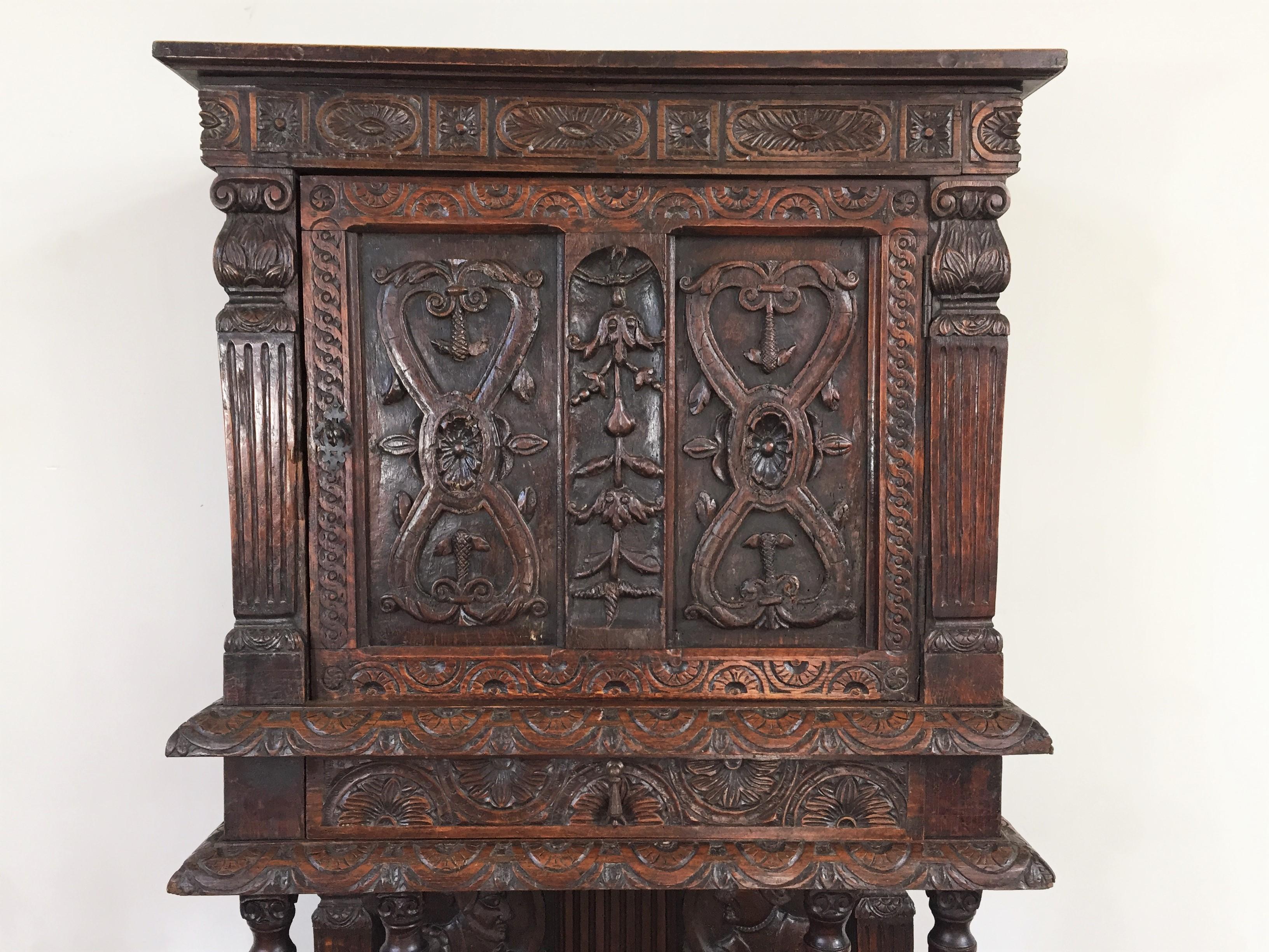 Beautiful carved credence cabinet opening at the top with a door and a drawer, with floral decoration and fluted pilasters, supported at the bottom by four fluted columns with Ionic capitals with a paneled background representing