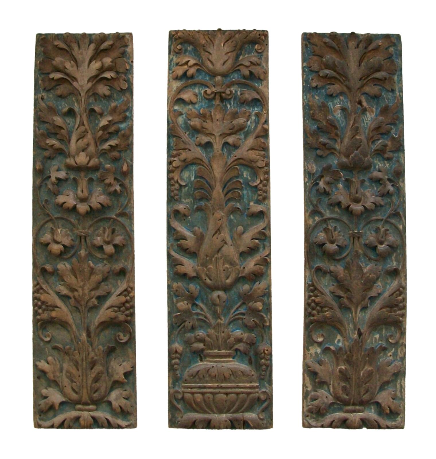 Exceptional Renaissance 'Grotesque' carved fruit-wood panels - featuring finely carved acanthus leaves bursting with fruit and flowers - retaining traces of the original gilded finish - original blue 'faux marble' painted backgrounds - one panel