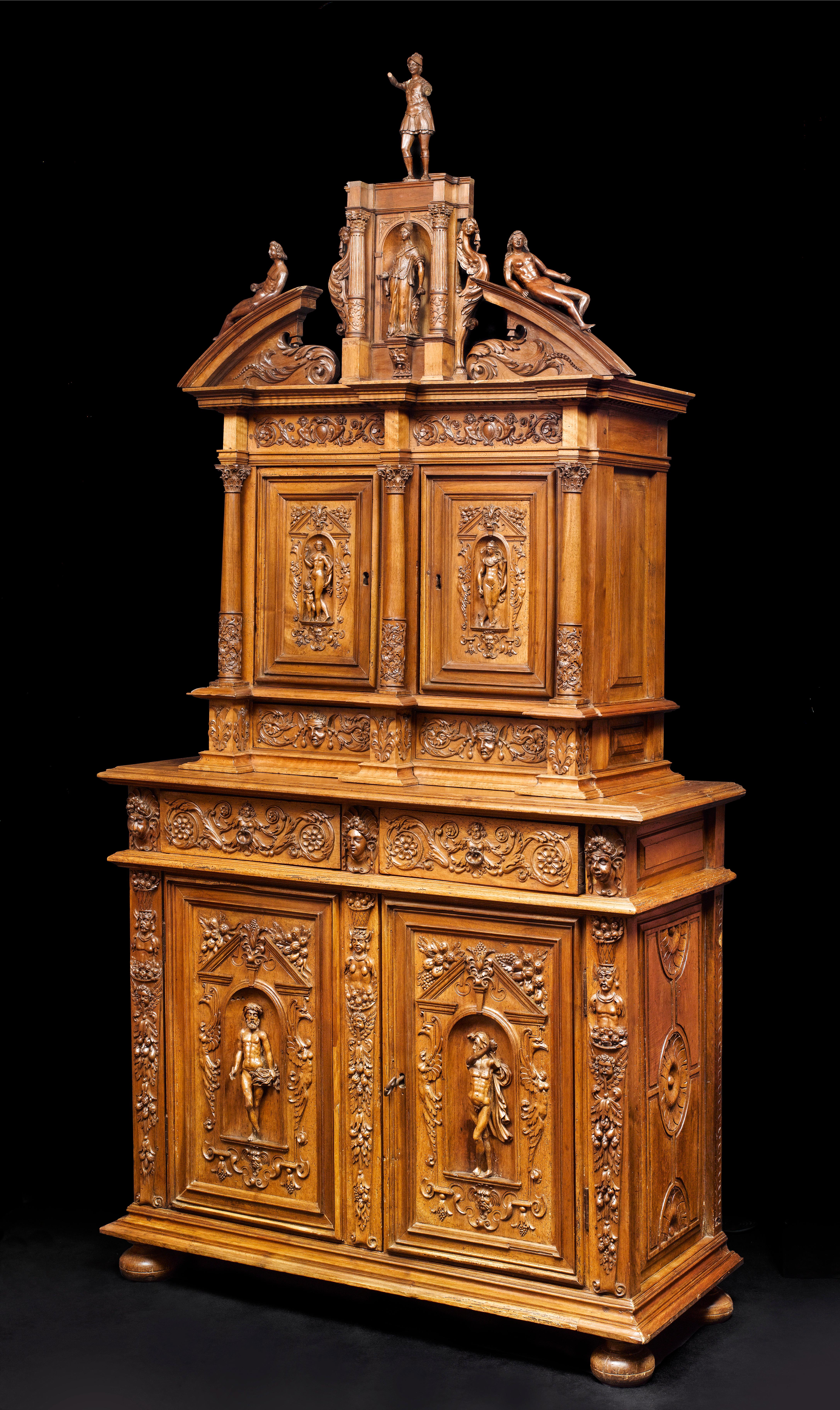 This cabinet is composed of two bodies, the upper one being recessed. The extraordinary proportions are enriched by a mythological and floral carved decor.

The Lower body stands on a moulded base with four bun-feet. It opens thanks to two