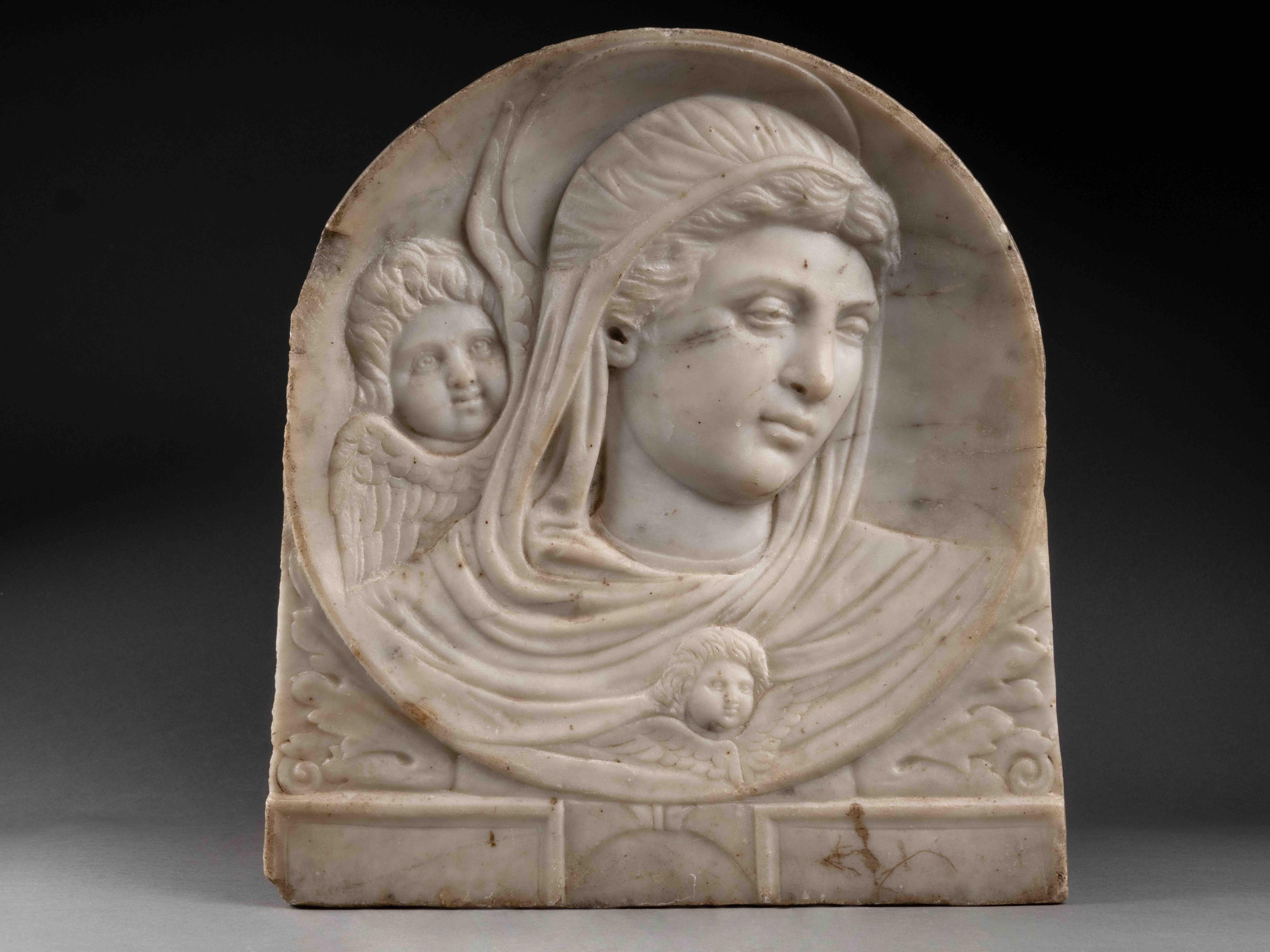 Renaissance Marble Relief 
Emilia Romagna, Faenza ? 1470-80
H 30,2 x L 33 x P 3,5 cm

The carved marble relief depicts the Virgin accompanied by a winged cherub standing behind her. The relief is set within a concave circle, where the Virgin's face