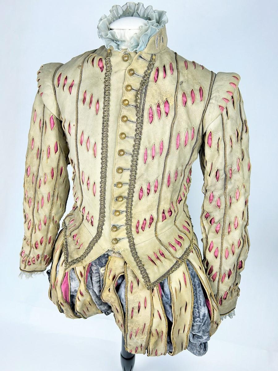 Circa 1940 in the 16th century style
France

From the back of the Comédie Française, a spectacular Renaissance period ensemble consisting of a doublet and breeches. Pale grey leather bottom with raspberry satin ribs, trimmed with gold metal buttons.