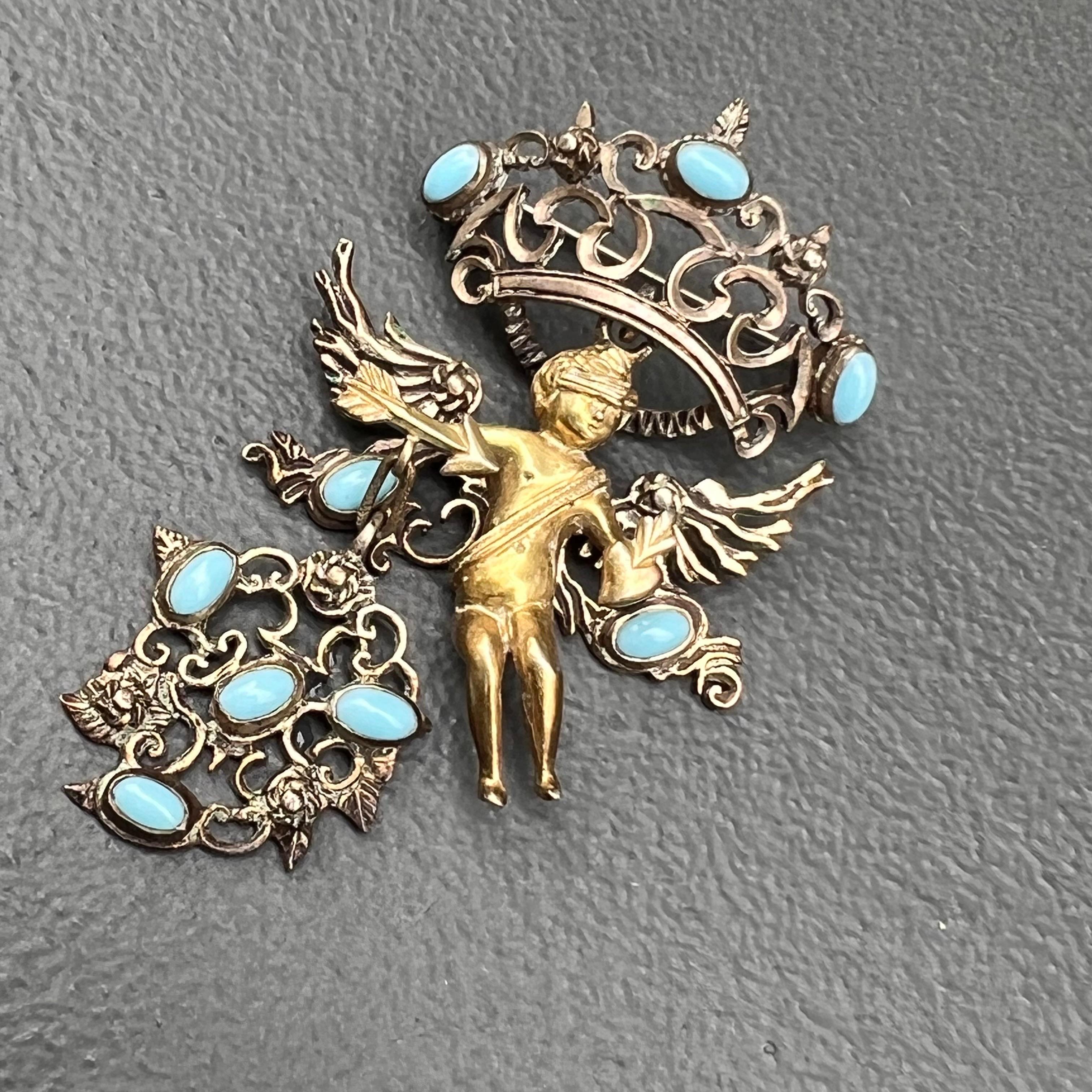 Antique Renaissance revival Austro Hungarian gold gilded silver articulated  pendant /pin / brooch featuring a detailed winged Cherub holding and arrow in one hand and heart in another . The top crown and bottom open work panel moves with movement