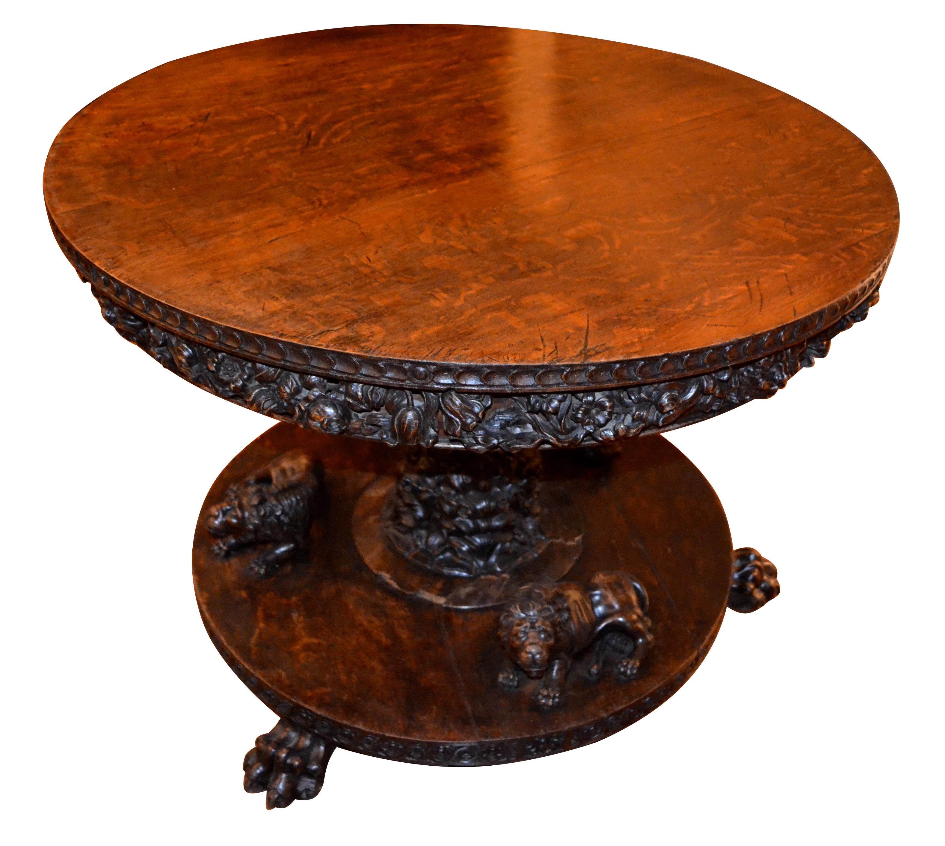 A heavily carved stained oak centre table in the Renaissance Revival style. The round top has a wide apron entirely carved with grotesque masks and ‘organic’ decoration; the underside of the top is also heavily carved, (see photos). The top is