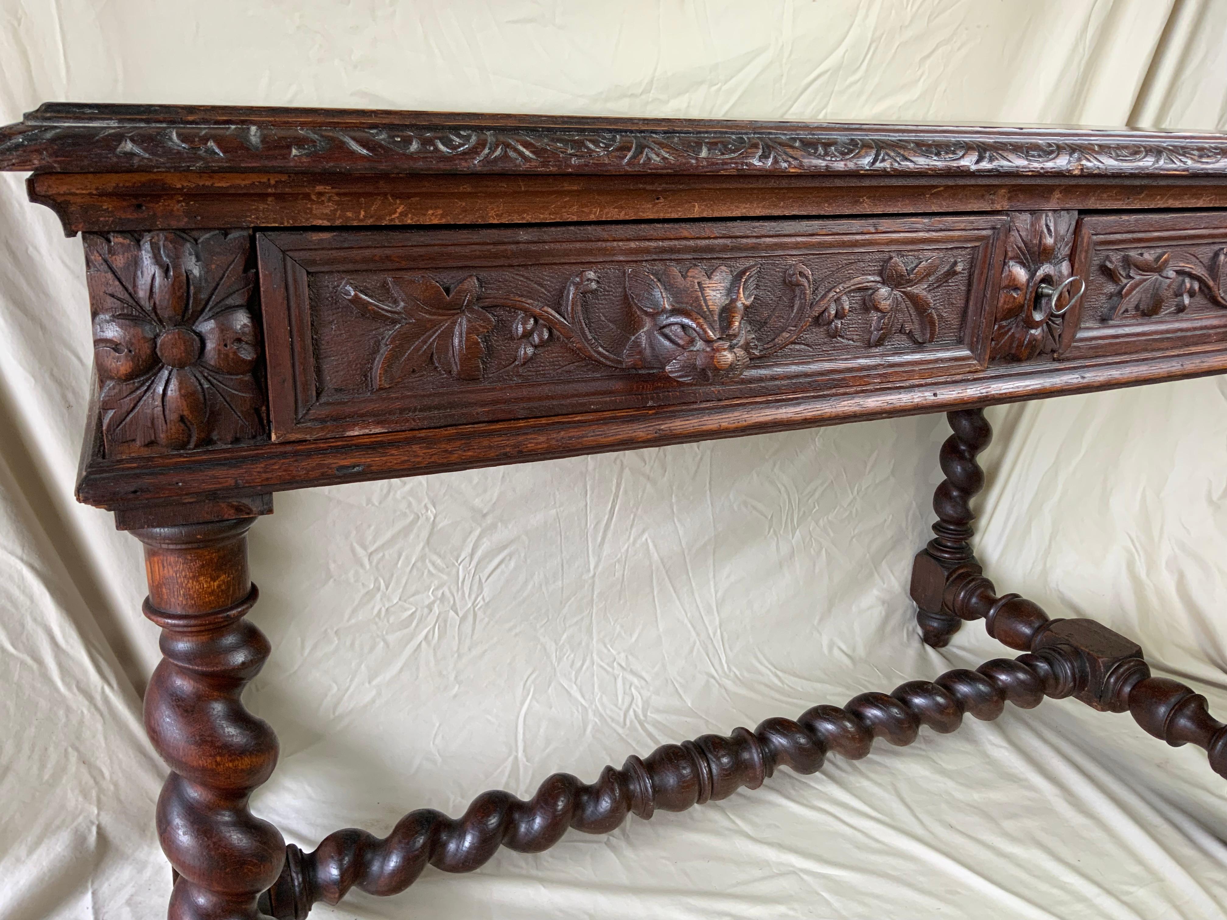 Antique French Desk or library Table Renaissance Revival last quarter 19th century.  Heavy Barley Twist legs and middle stretcher.  Two drawers with carved heads and the original center drawer lock and working key. Original surface with a finely age