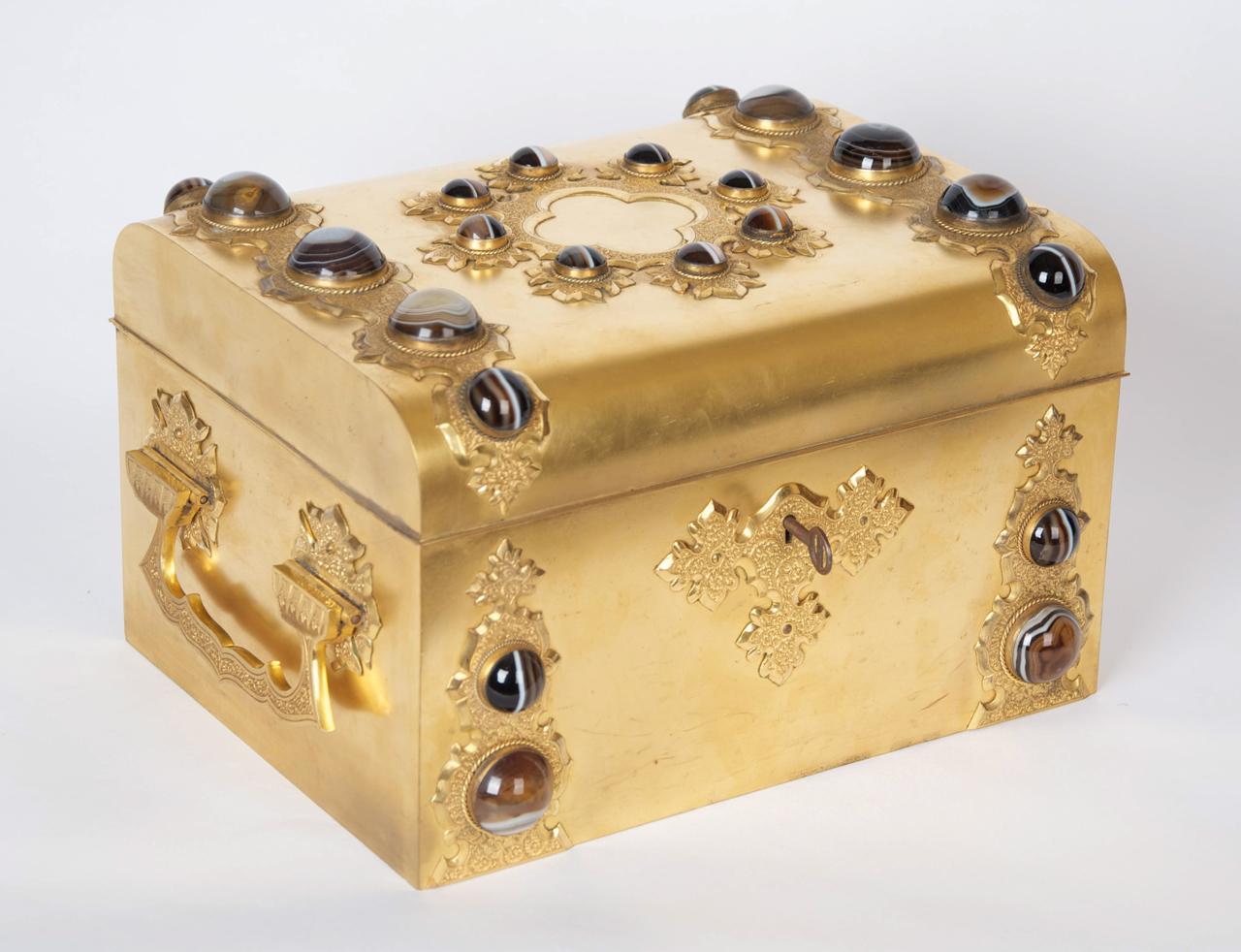 A Renaissance Revival gilt-brass and agate mounted dressing table box.

French, circa 1870. 

This fine box is applied with foliate engraved strap-work and side handles and finely polished agate cabochons. The interior is fitted with cut-glass