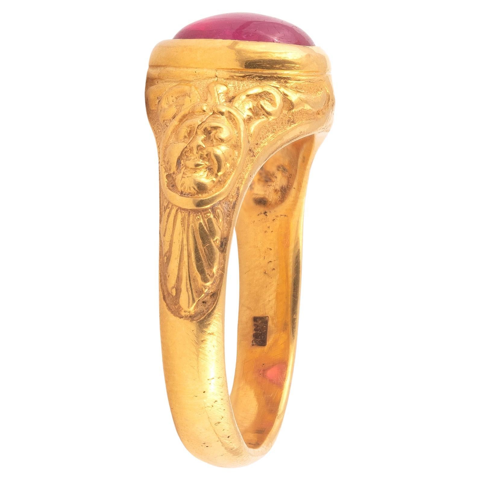 Gold ring with embossed masks and cabochon ruby. This sculptural ring is cast in gold and finely chased.
Size 8
Weight: 9,6gr.