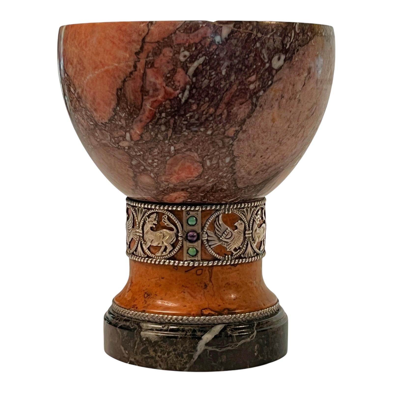 Our Renaissance Revival period chalice is carved from variegated marble and features a band at the waist of silver depicting birds and mammals and cabochon shaped turquoise and ruby colored semi-precious stones. Unsigned.