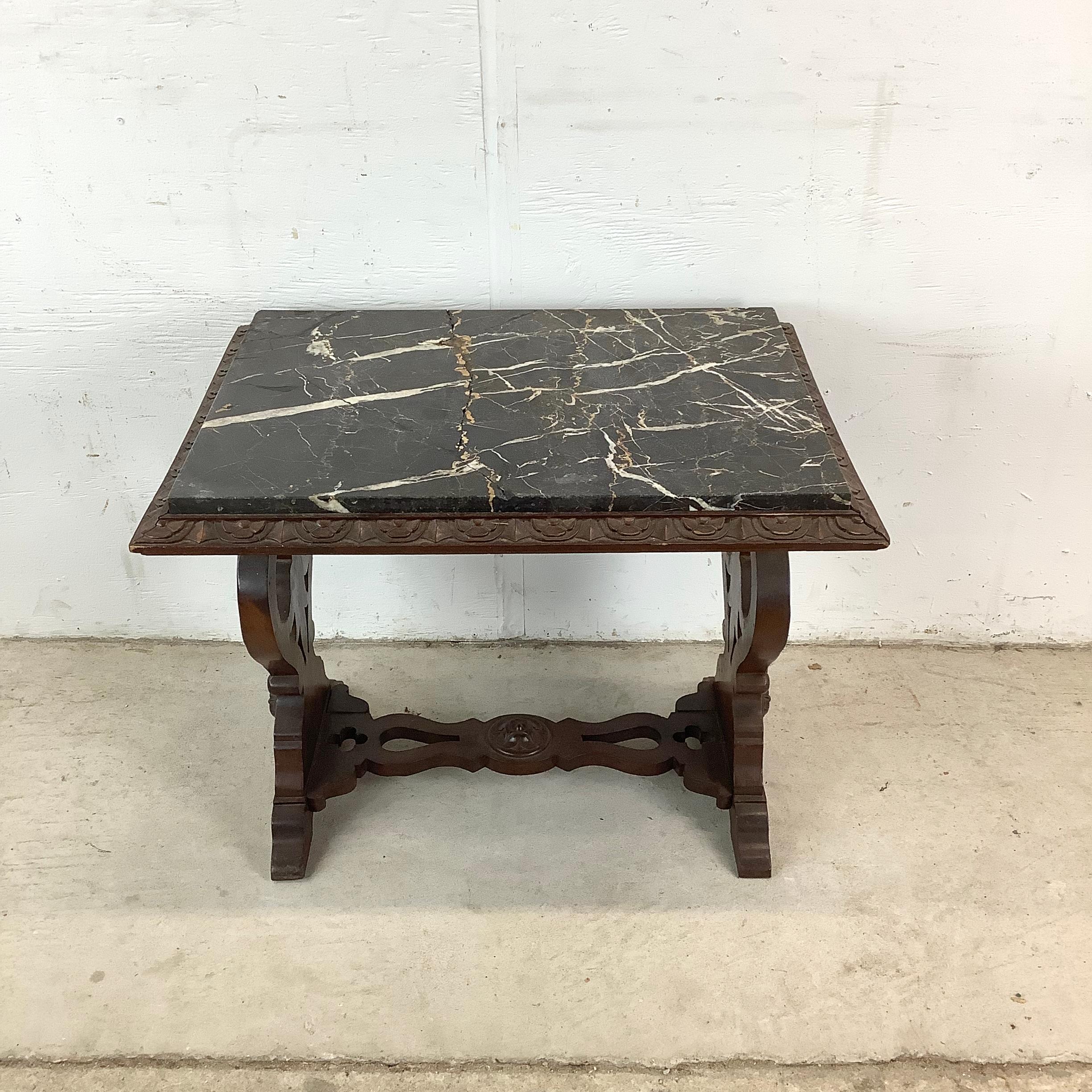 This vintage Renaissance-style table offers a stunning combination of dark marble and intricate wood carving. Its rectangular stone top rests securely above a sculptural base that feels both stately and inviting.

Decorative cutouts and relief