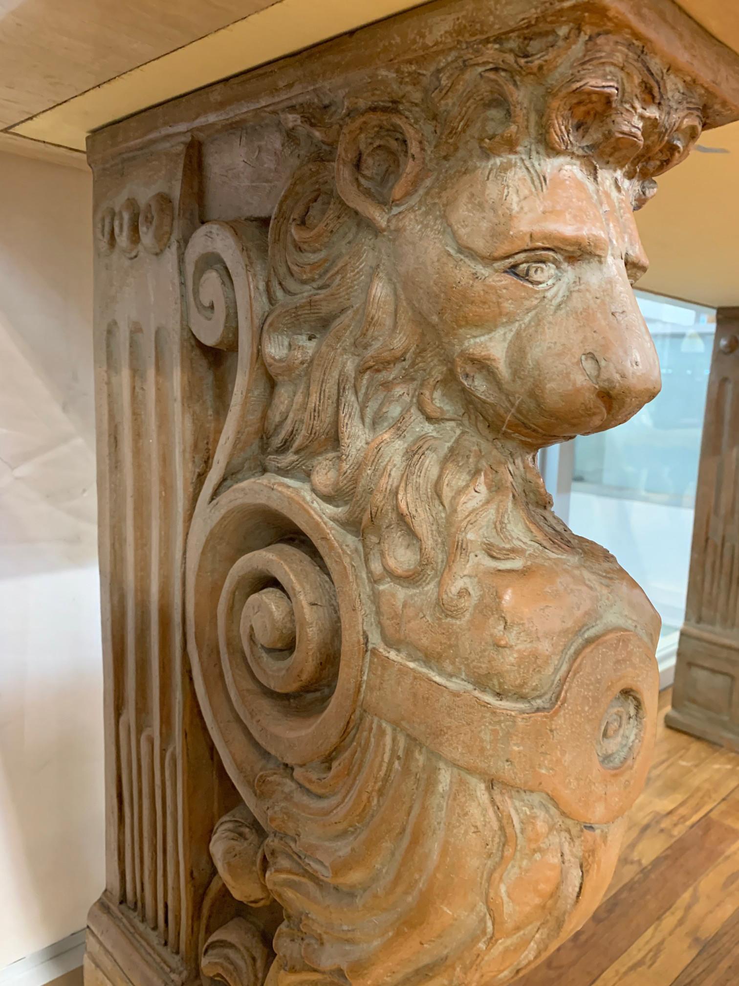 Renaissance Revival style console table featuring polished travertine top over carved terracotta lion corbel supports. Measures: 32