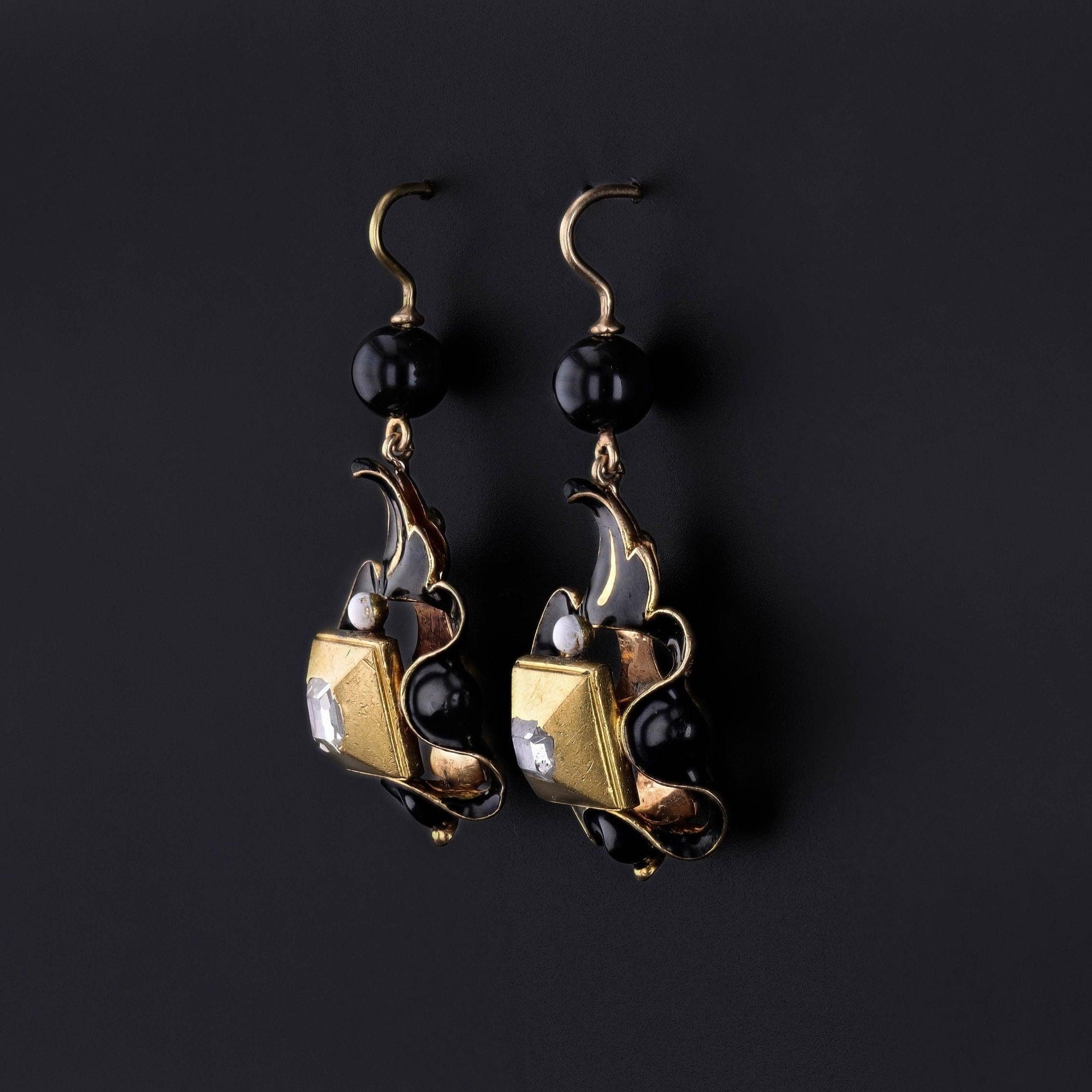 Renaissance Revival Diamond Earrings: A rare pair of 19th century Renaissance Revival earrings (circa 1850-1880) in 22ct rub over settings with 18k black and white enamel drops, leaded glass bead surmounts, and 14k gold ear wires. The drops date to