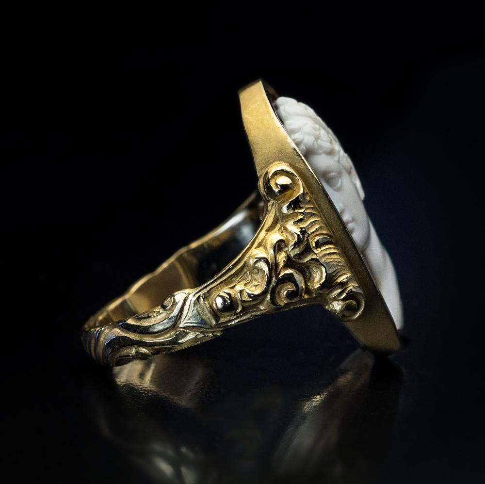 Circa 1880

This ornate 19th century Renaissance Revival 14K gold unisex ring features an intricately carved sardonyx cameo of a classical Greco-Roman male bust in profile.

The cameo measures 22 x 15 mm (7/8 x 5/8 in.), with bezel – 24 x 17 mm