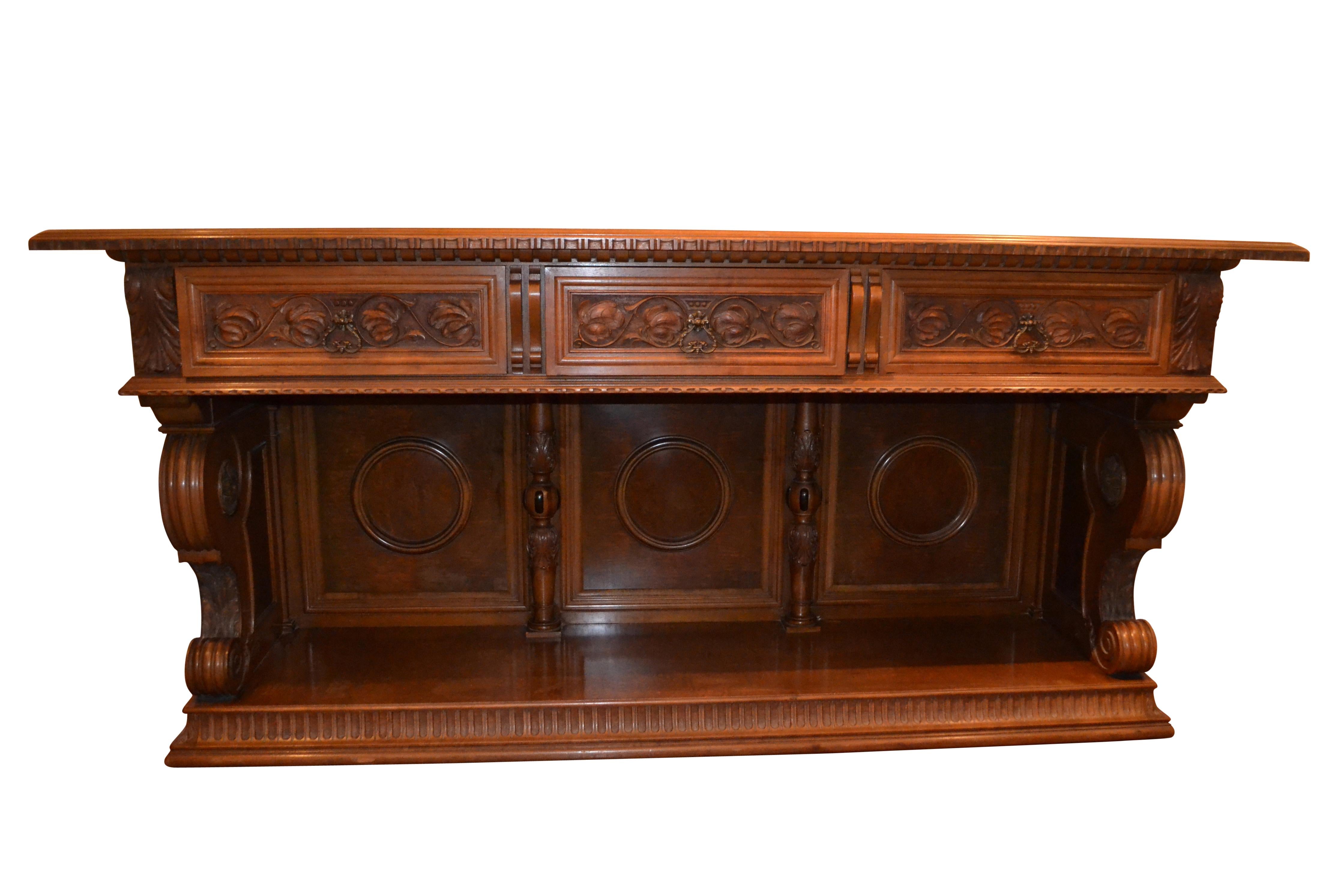 A finely carved walnut sideboard/credenza in the Renaissance Revival style, made in the United States by the Royal Furniture Company Grand Rapids Michigan at the turn of the 20 Century. There are three pull-out drawers one with  a bronze Royal
