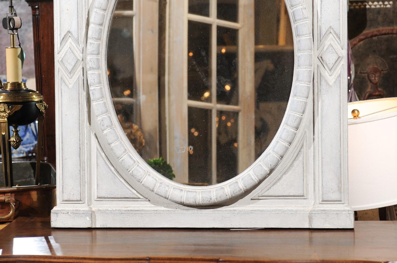 A Renaissance style Belgian painted wood mirror from the mid-19th century, with broken arch pediment and oval mirror plate. We currently have two available, priced and sold individually. Born in Italy during the 1850s, this exquisite Renaissance