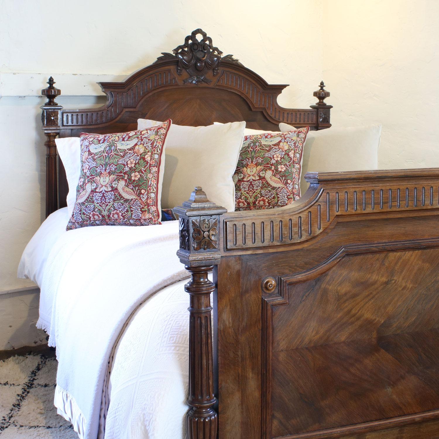 A Renaissance style bedstead with decoratively carved head mount and tapered and fluted posts. 

This bed accepts a British king size or American queen size, 5ft wide (60 inches or 150cm) base and mattress set.

The price includes a firm bed