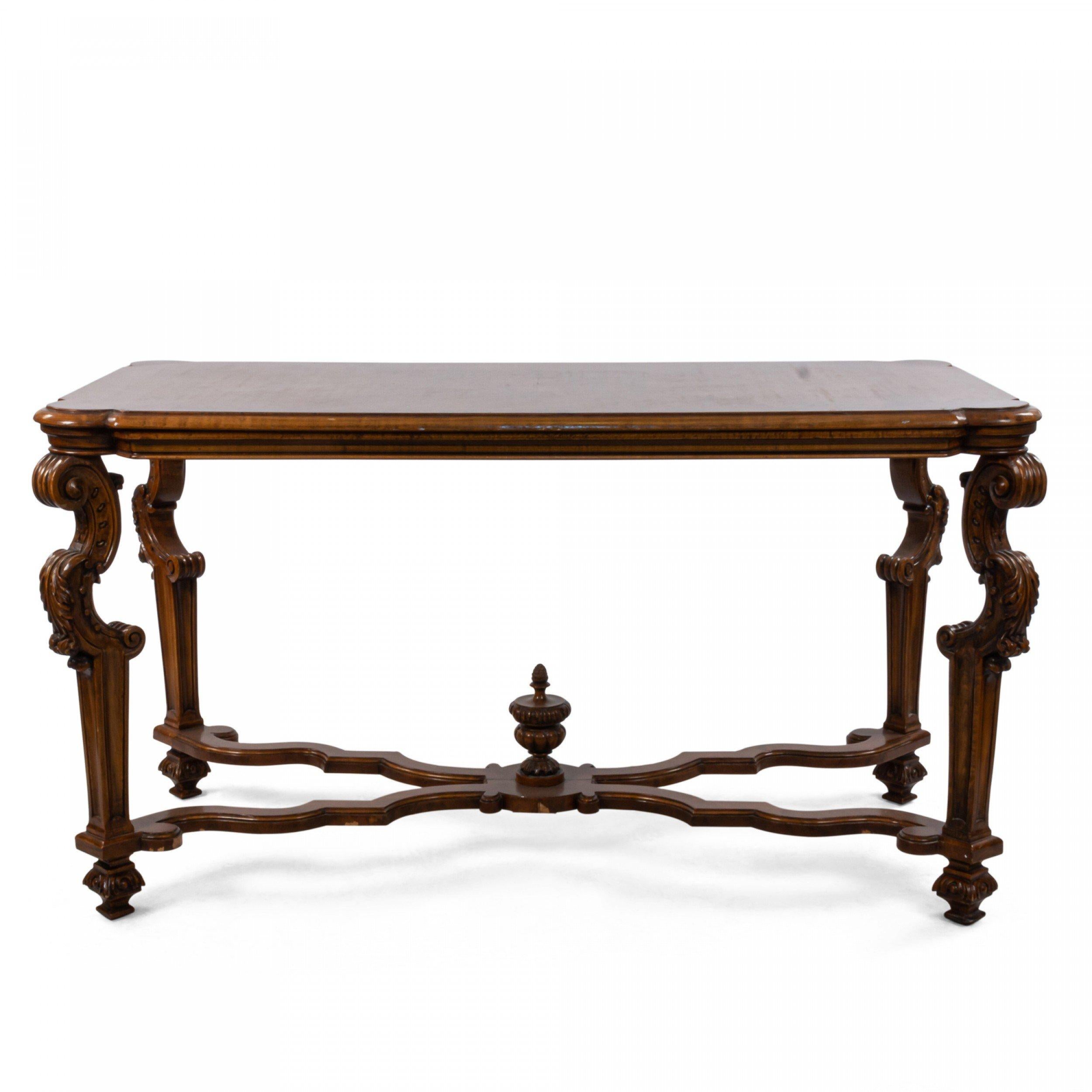 20th century Italian Renaissance style walnut center / dining table with a scalloped X-bar stretcher and legs having a cabriole top over a tapered square design.