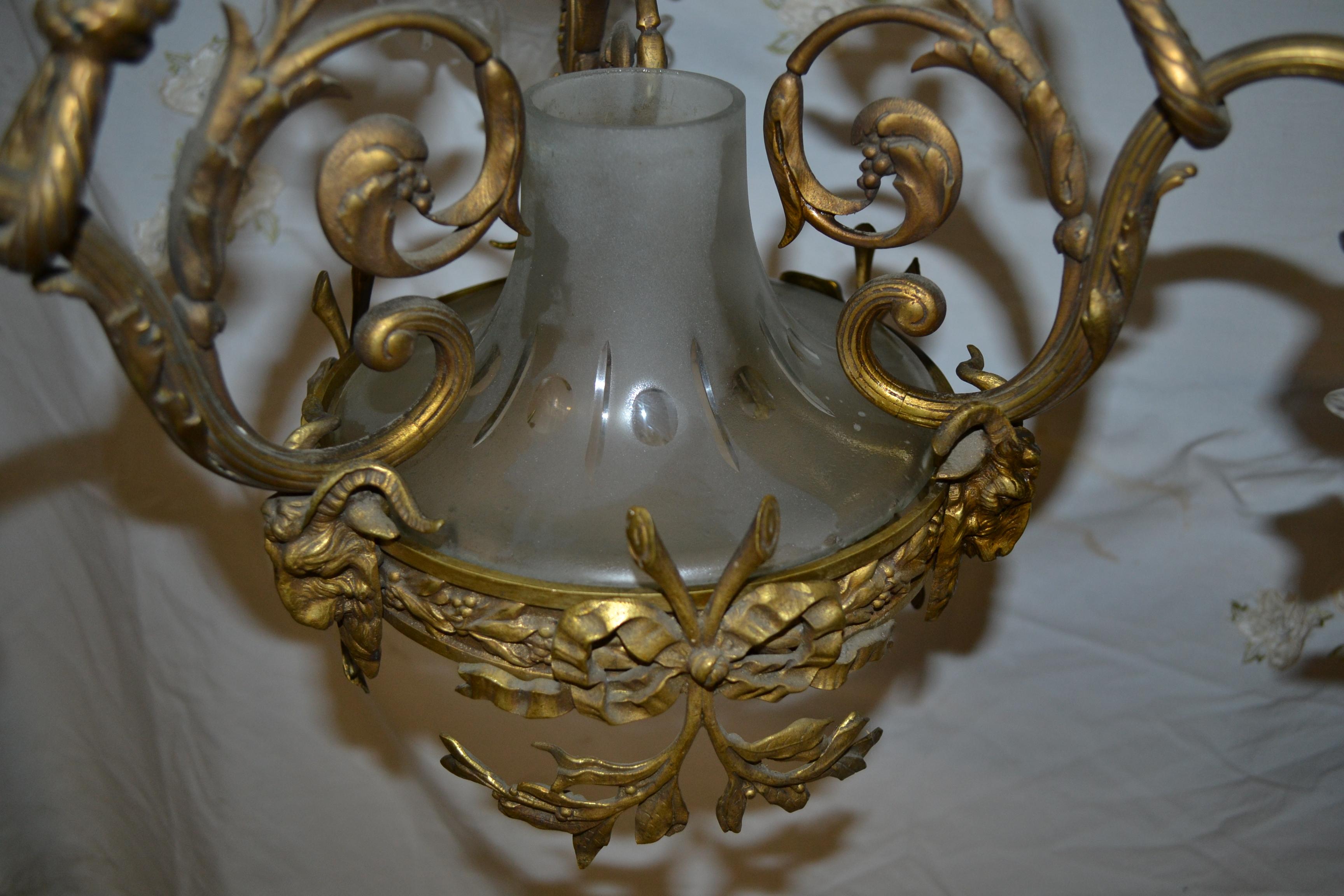 A very fine French 19th-20th century Belle Époque gilt bronze and patinated bronze three-light chandelier, with frosted glass shades shaped as flower petals, centred with a frosted edged-glass urn. Three main branches in the shape of rope lead to