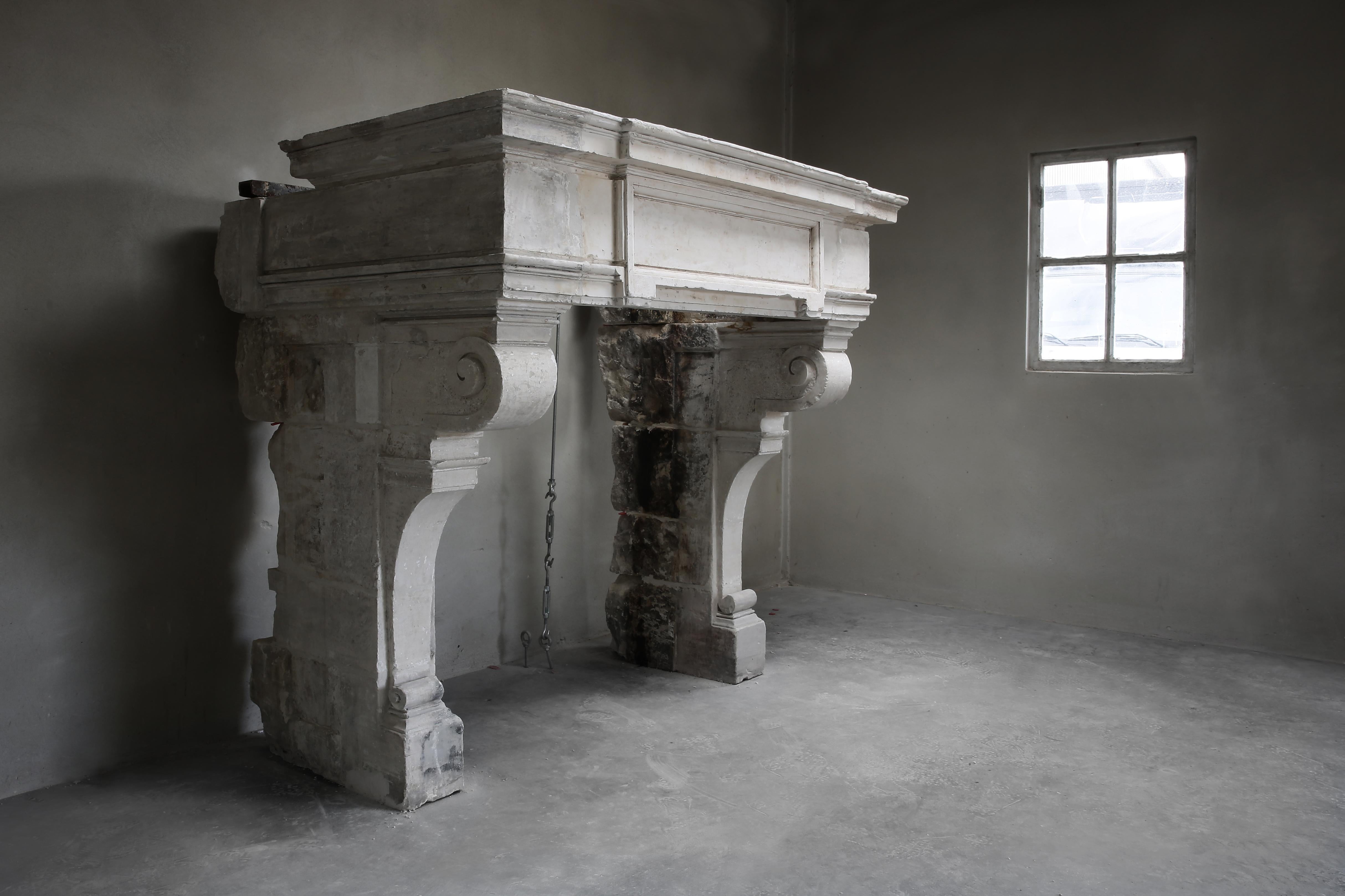 A magnificent antique French limestone fireplace in Renaissance style! This historic mantel (fireplace) dates from the 18th century and exudes a lot of allure due to its robustness and shape. A fireplace with a wide top and various ornaments. The