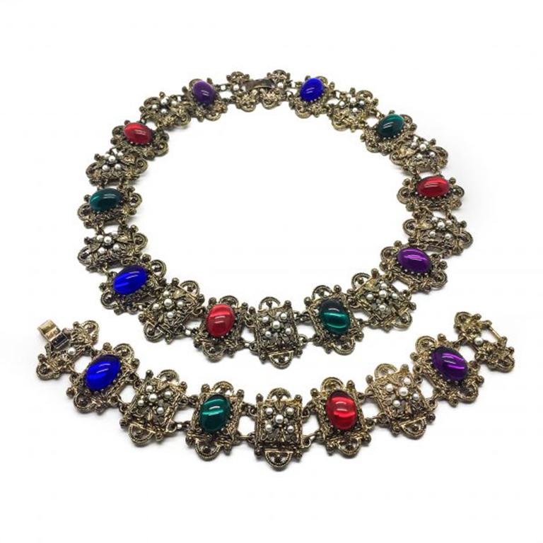 A really striking Renaissance style set from the 1980s. Featuring vibrant and glamorous resin jewel colored cabochons in gilt metal with faux seed pearls. In very good vintage condition. Necklace 46.5cm, Bracelet 19.5cm. This set really is the