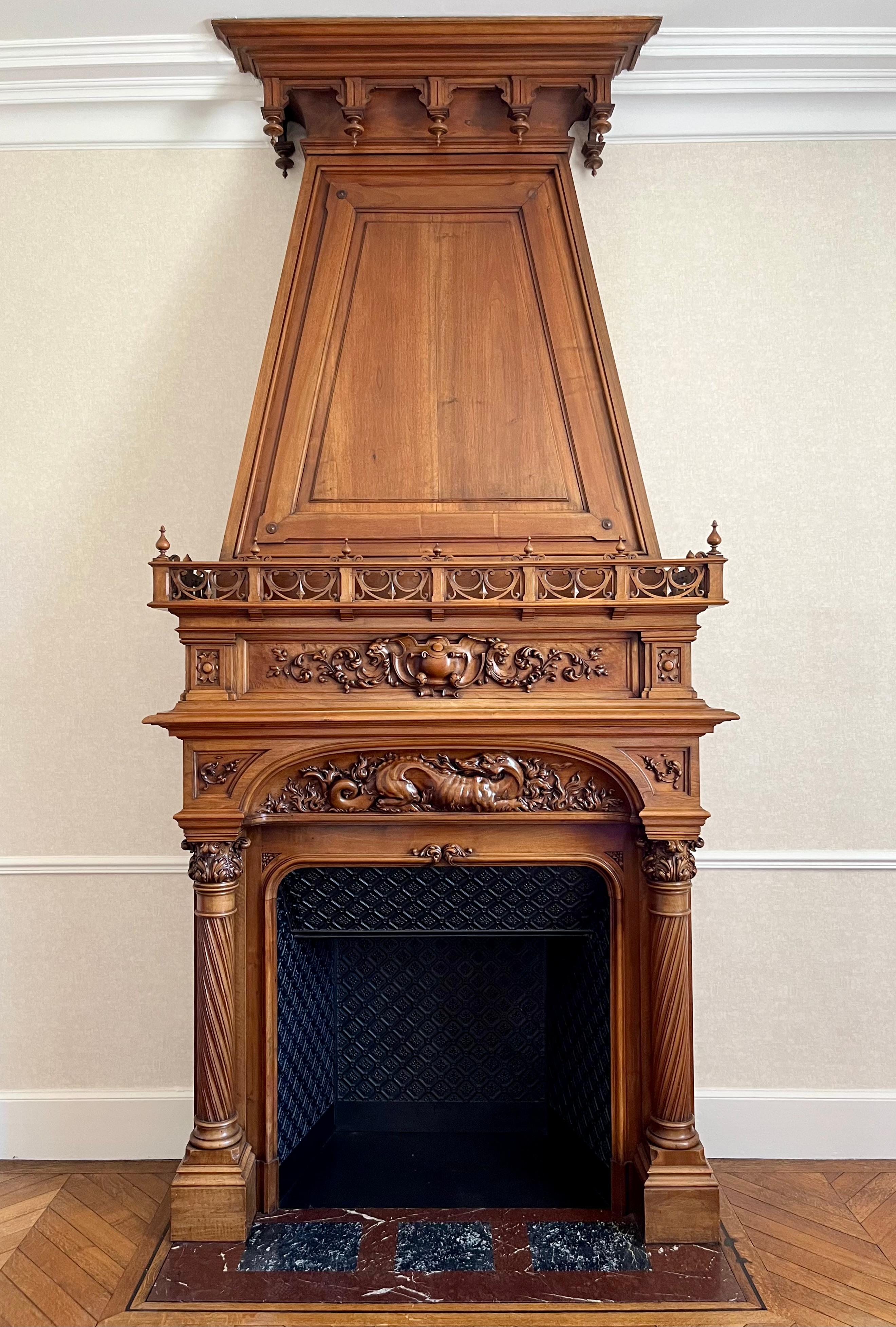 Sumptuous and majestic castle fireplace in solid walnut in Renaissance style richly carved with acanthus leaves with in the center the emblem of Francis I, a fire-spitting salamander. It is complete and in very good condition. Original cast iron