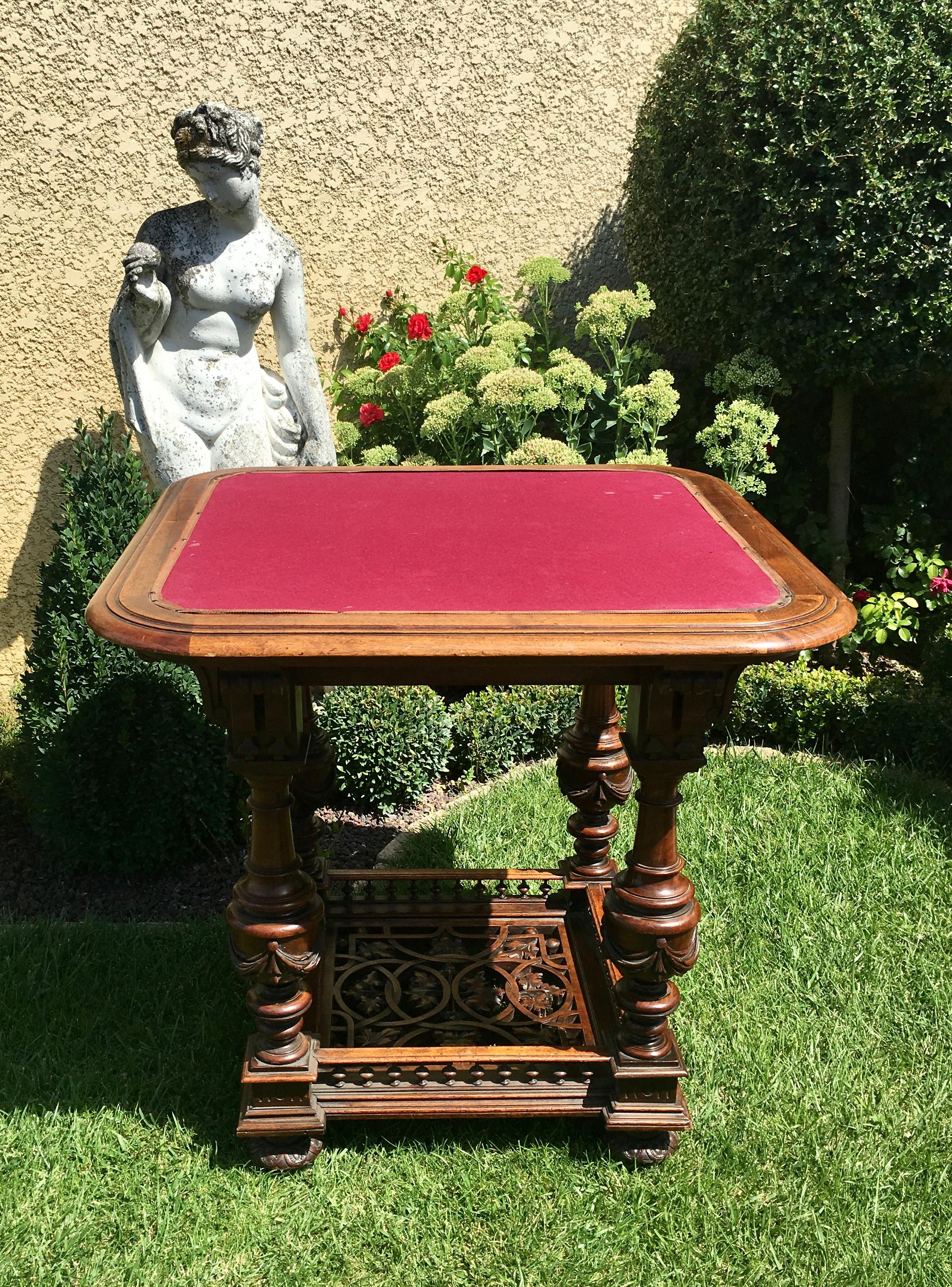 Renaissance style walnut games table. This table has two zippers on either side and rests on 4 baluster-shaped legs connected by a fully sculpted and openwork spacer. French work of very good quality and dating from the 19th century. This table is