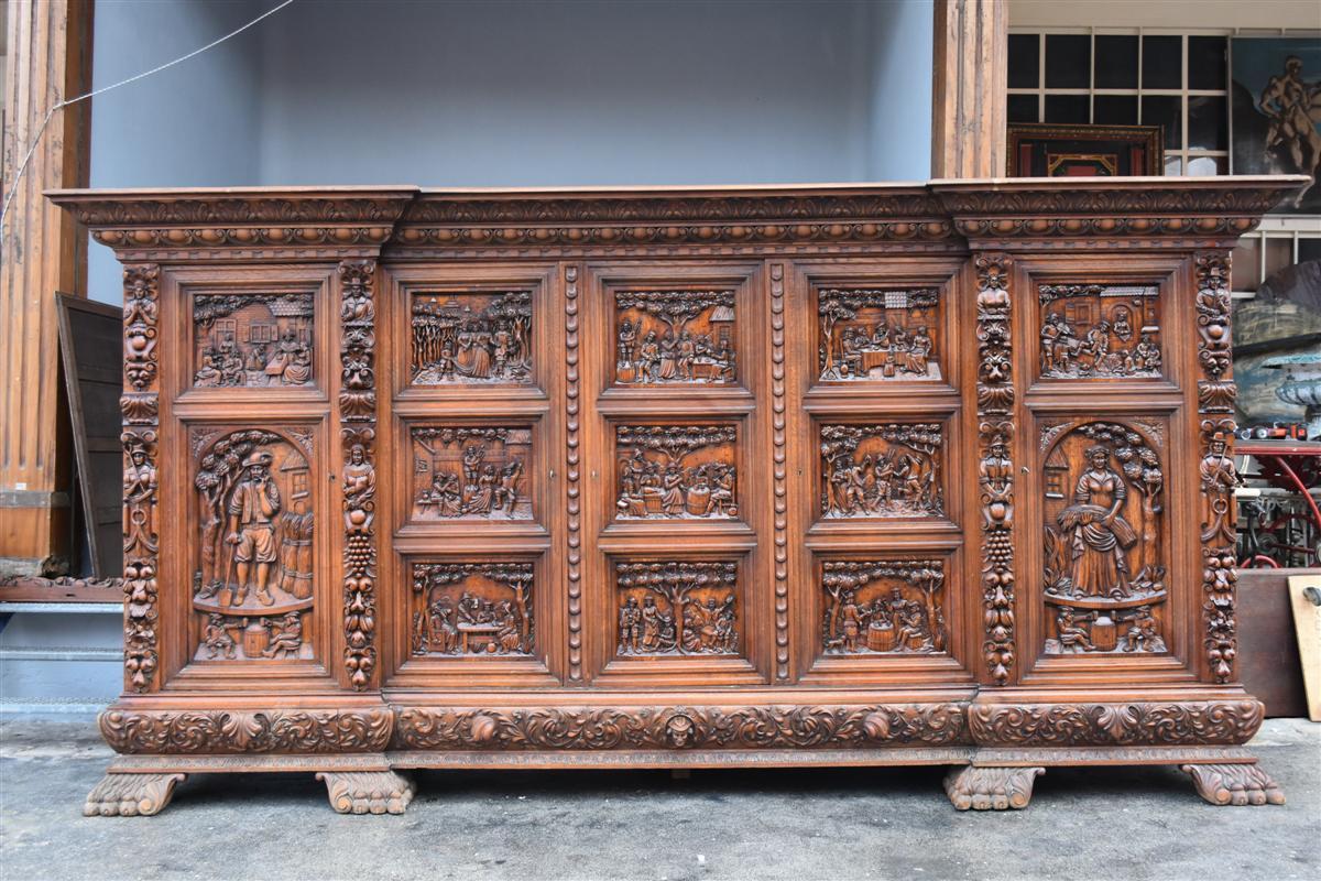 Exceptional richly carved Renaissance style wardrobe decorated with sketches with many characters depicting various rural scenes extraordinary size. Outstanding standards and remarkable sculpture quality. Period first half of the 20th century.