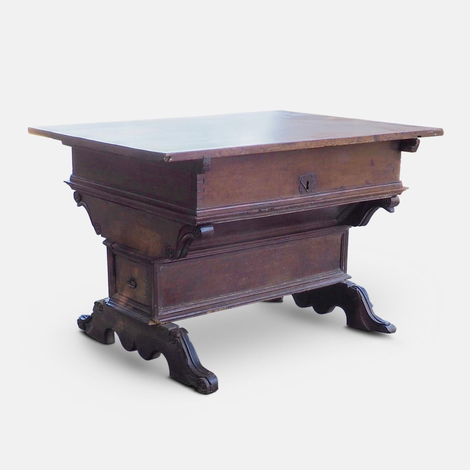 Very rare Renaissance merchant's desk from the late 16th century. A beautiful desk decorated with carved foliate roundels and mitred trim of walnut.  This table has an exceptionally nice form and color. The sliding top opening to a large compartment