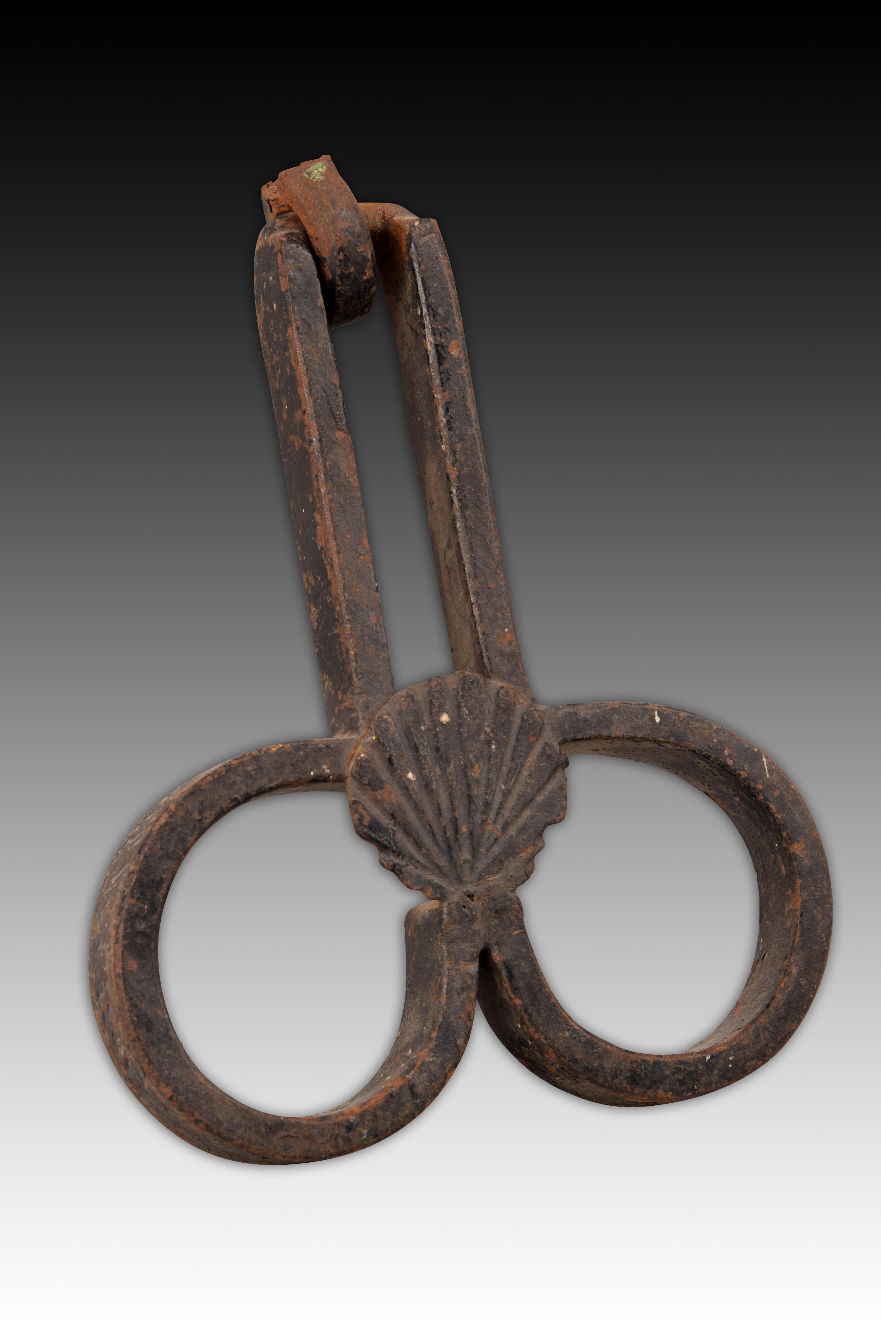 Shooter. Wrought iron, 16th century.
Handle made of wrought iron and formed by several pieces arranged in a particular way, which gives this type its name (scissor handle). The rectangular area and the two facing simple scrolls have been placed