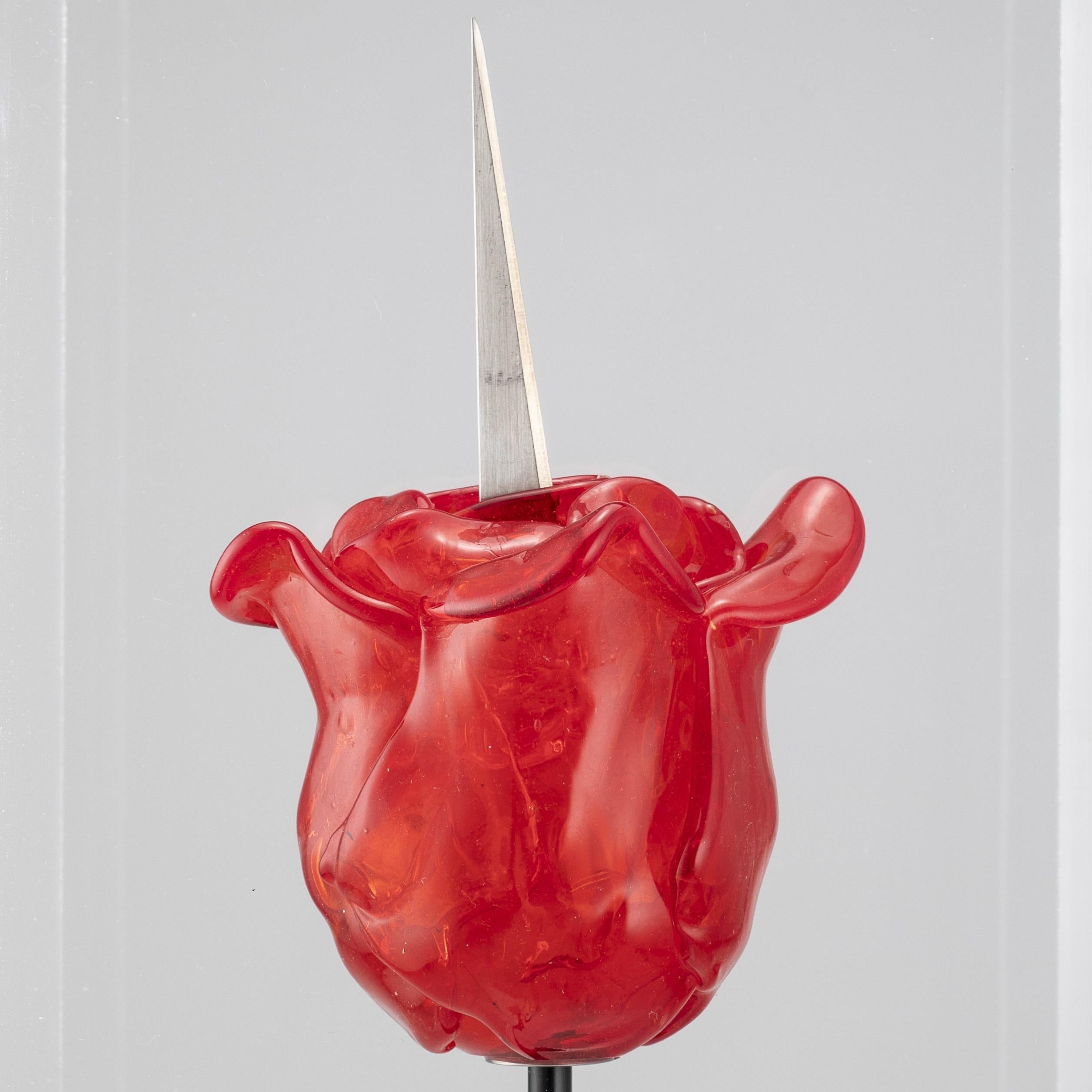 Dans le prolongement de son installation évocatrice de la Biennale de Venise, Bertlmann crée cette sculpture comme un symbole à la fois d'attractivité et de force.

Rose-couteau de Renate Bertlmann 
Verre de Murano et métal, protégé par un étui en