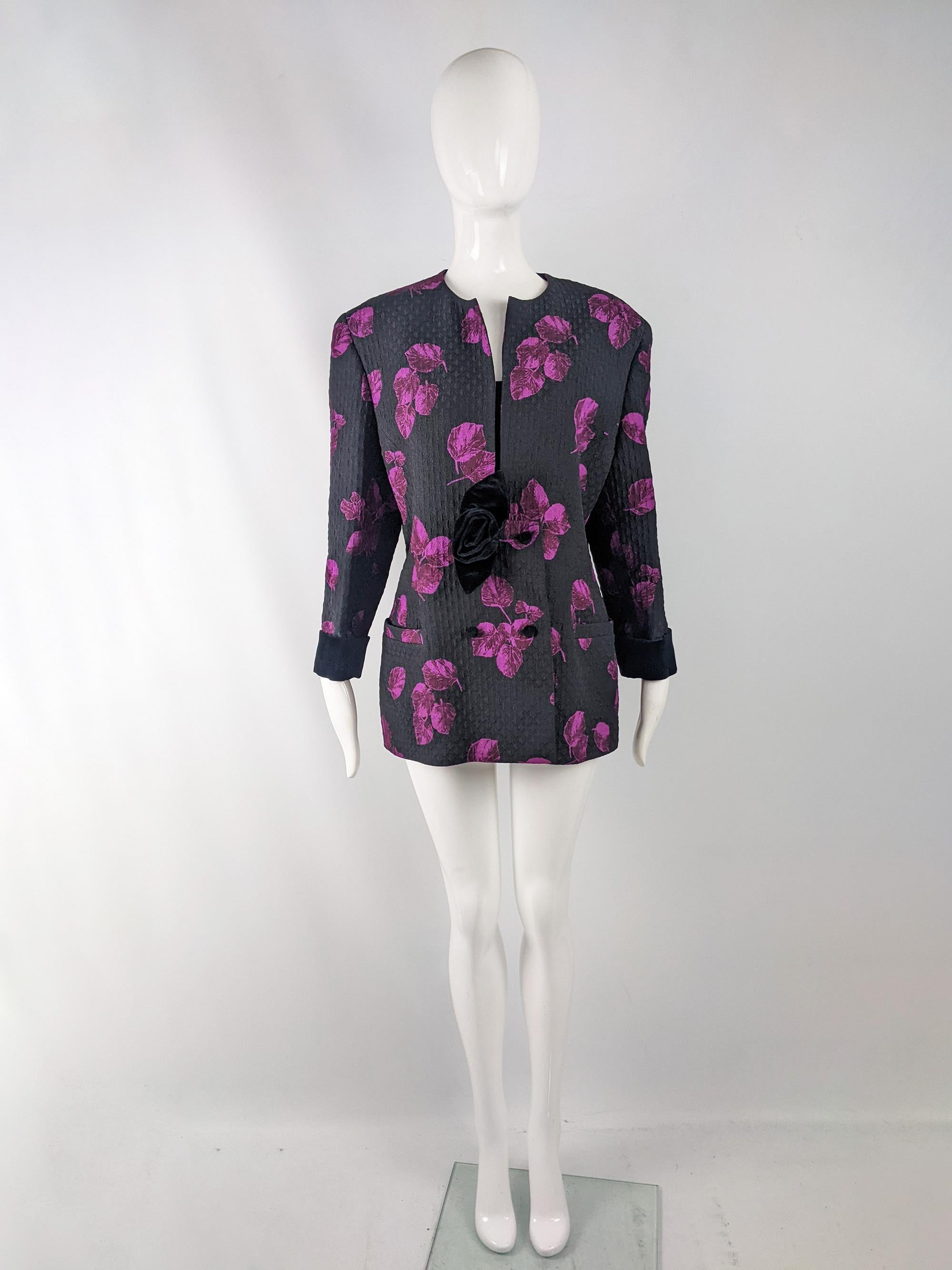 A fabulous and sassy vintage womens blazer from the 80s by luxury Italian fashion designer and couturier, Renato Balestra. In a black matelassé quilted cotton fabric with a sophisticated yet bold purple floral print throughout. It has a velvet trim