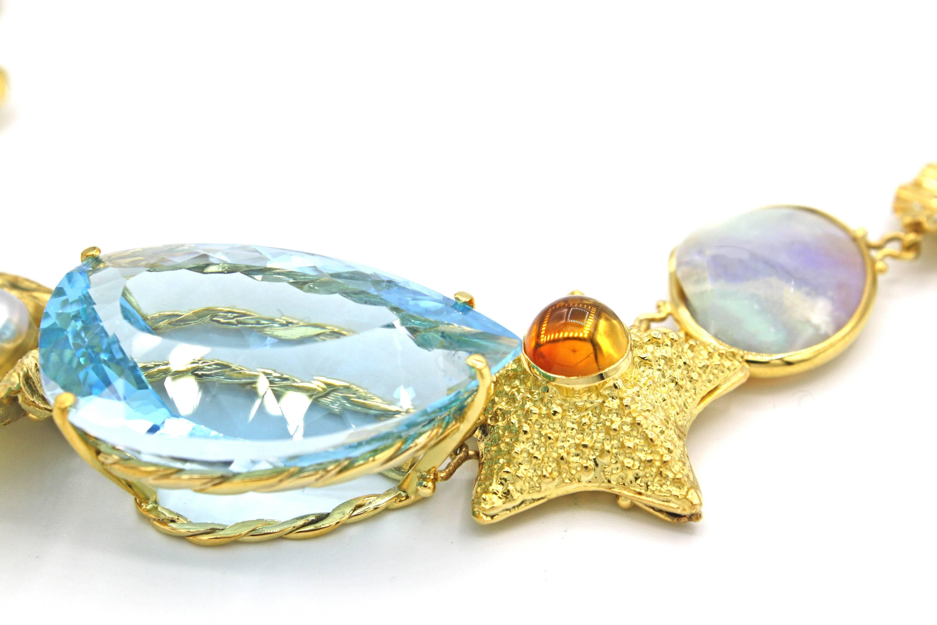 This stunning one-of-a-kind necklace is from Renato Cipullo's Return to the Sea Collection.  Featuring a center 75ct blue topaz accompanied by a variety of 18k yellow gold sea motifs including a turtle with emerald eyes and citrine shell, crab with