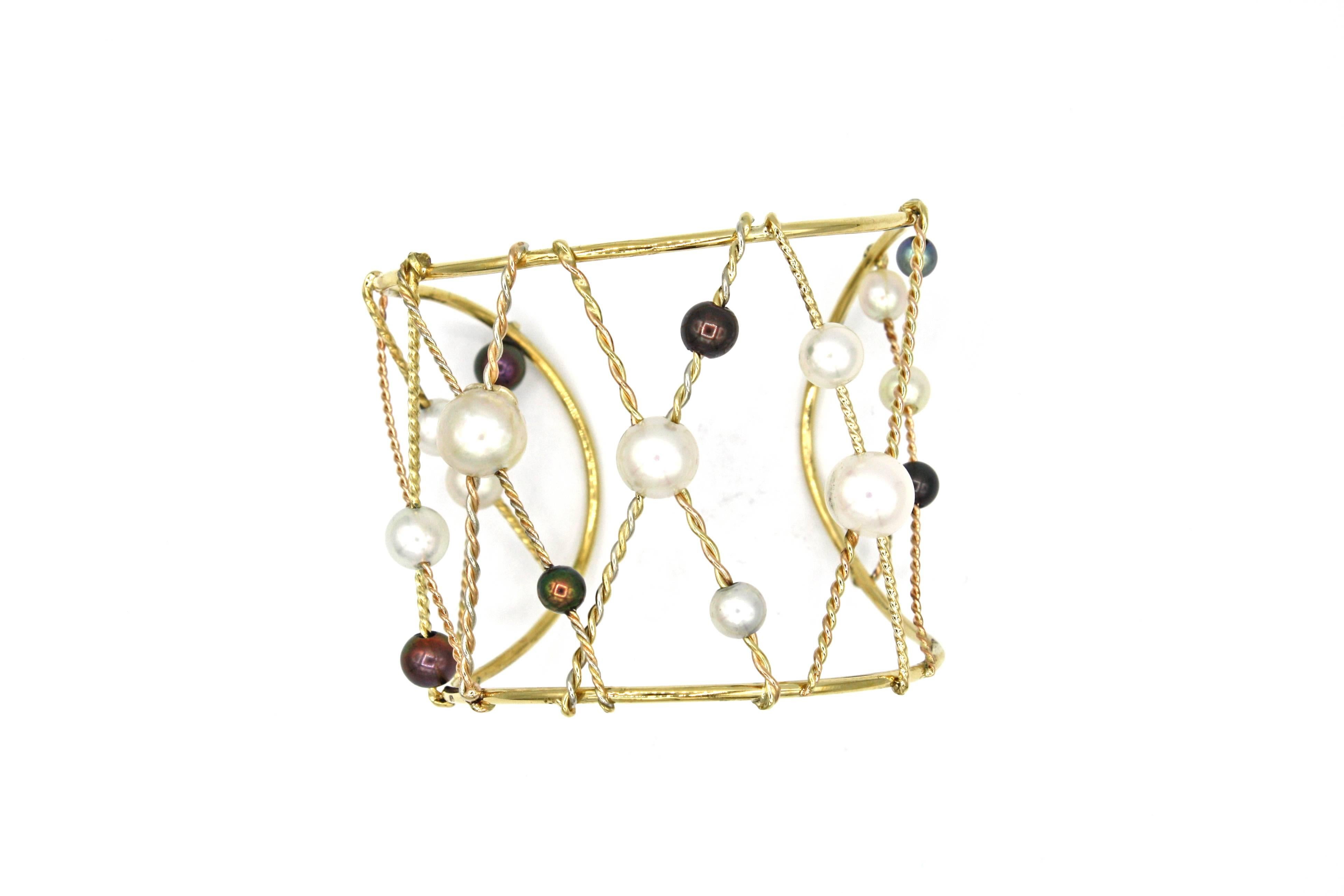 This elegant cuff bracelet is made of 18k yellow, rose, and white gold intertwined to appear like rope along with 16 South Sea pearls in varying colors.