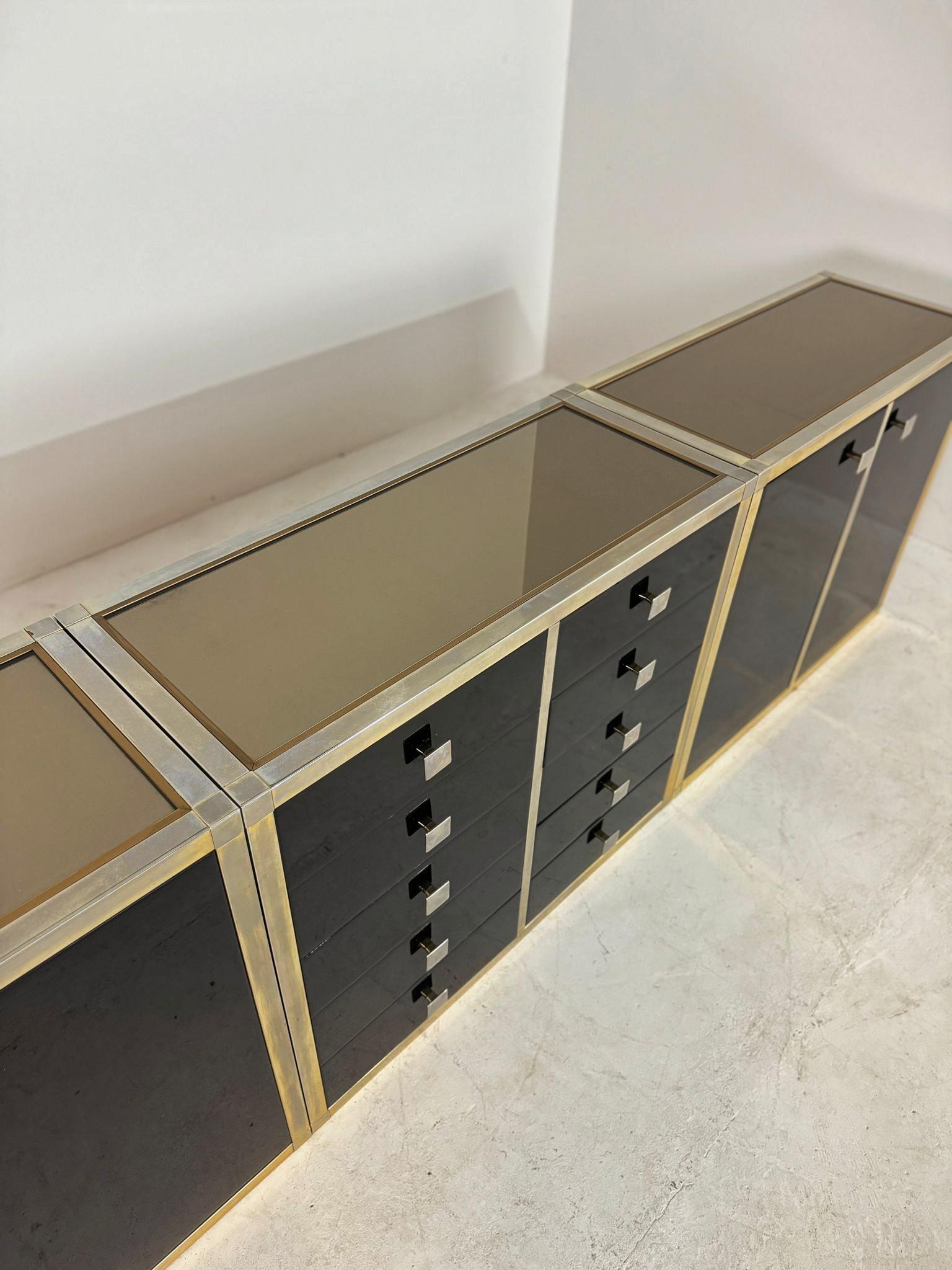 Stunning sideboard in very good condition.

Designed by Renato Zevi in the 1970s, Italy.

The sideboard consists of three pieces which also can be used separately.

Each element has a brass framing and black laminated panels and fronts and a glass