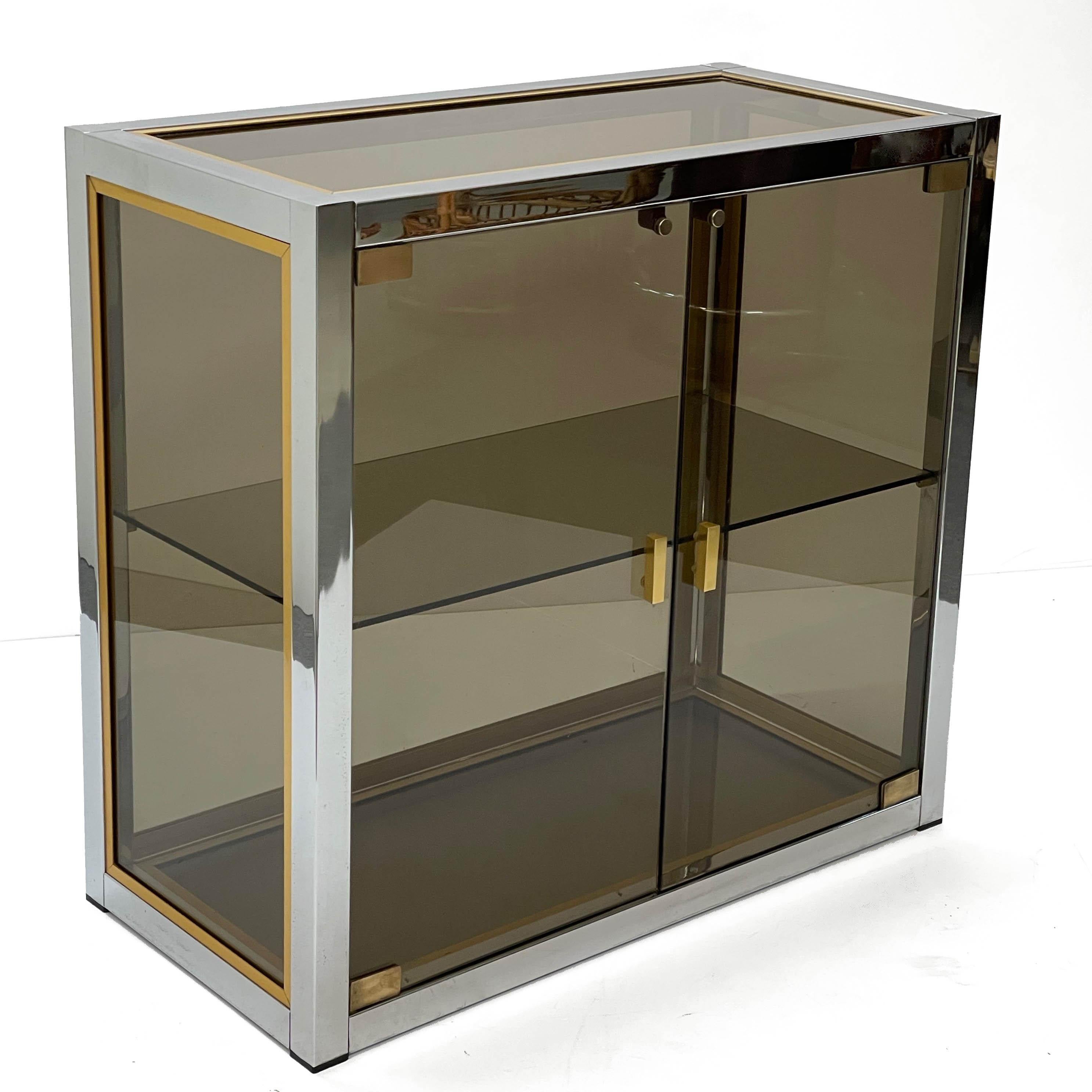 Amazing midcentury smoked glass doors with chrome finishes and smoked glass shelves. This fantastic piece was designed by Renato Zevi in Italy during the 1970s.

This item is extremely charming because of the material mix, smoked glass for doors