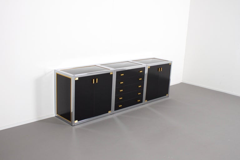 Stunning sideboard in very good condition.

Designed by Renato Zevi in the 1970s 

The sideboard consists of three pieces which also can be used separately.

Each element has a brass and chrome framing and black laminated panels and fronts.

The