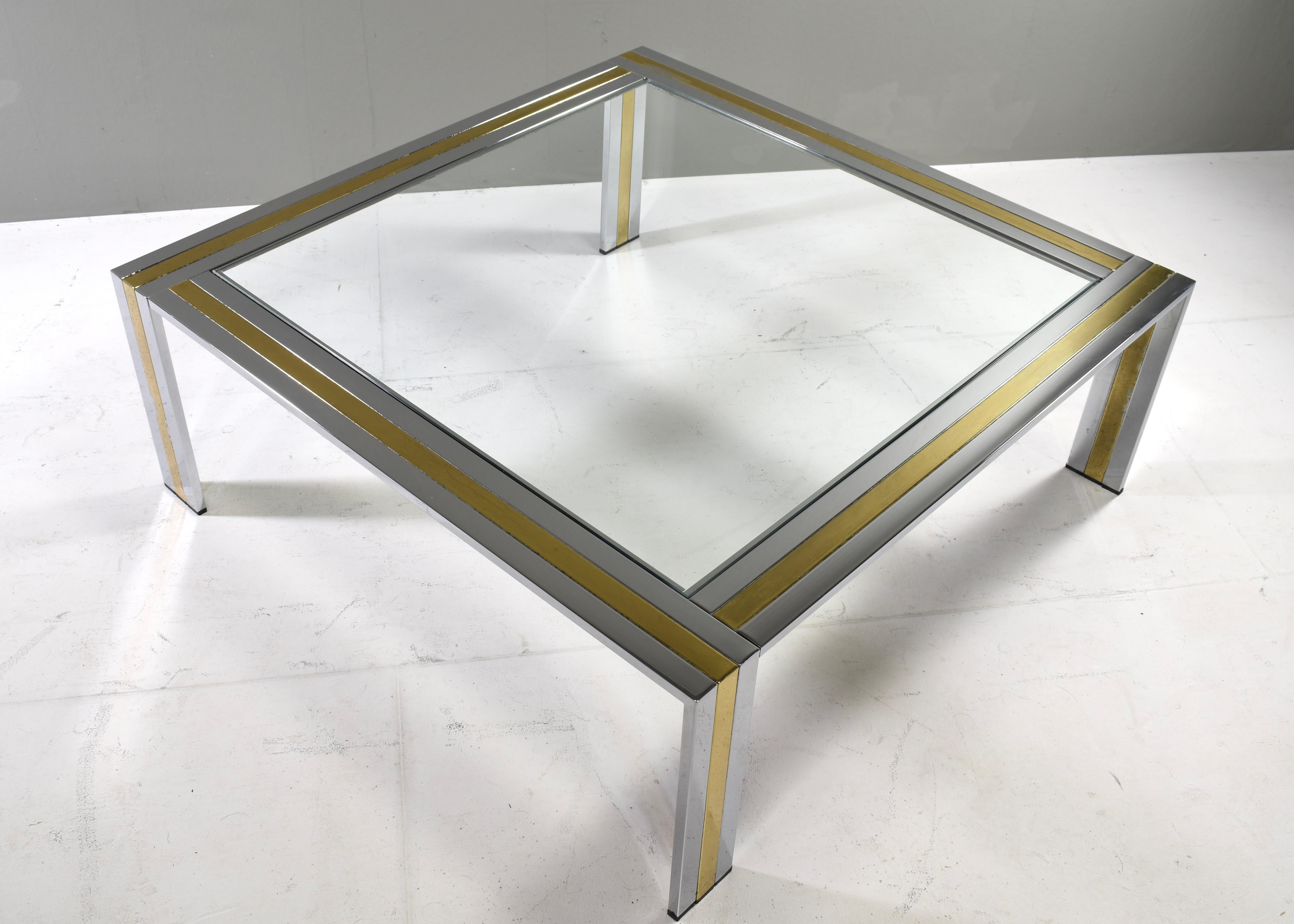 Table basse carrée Renato Zevi en chrome, métal laitonné et verre transparent, Italie - vers 1970.
La table est en bon état avec des signes d'âge, d'utilisation et de patine. Le chrome est globalement en très bon état. Le laiton présente à certains